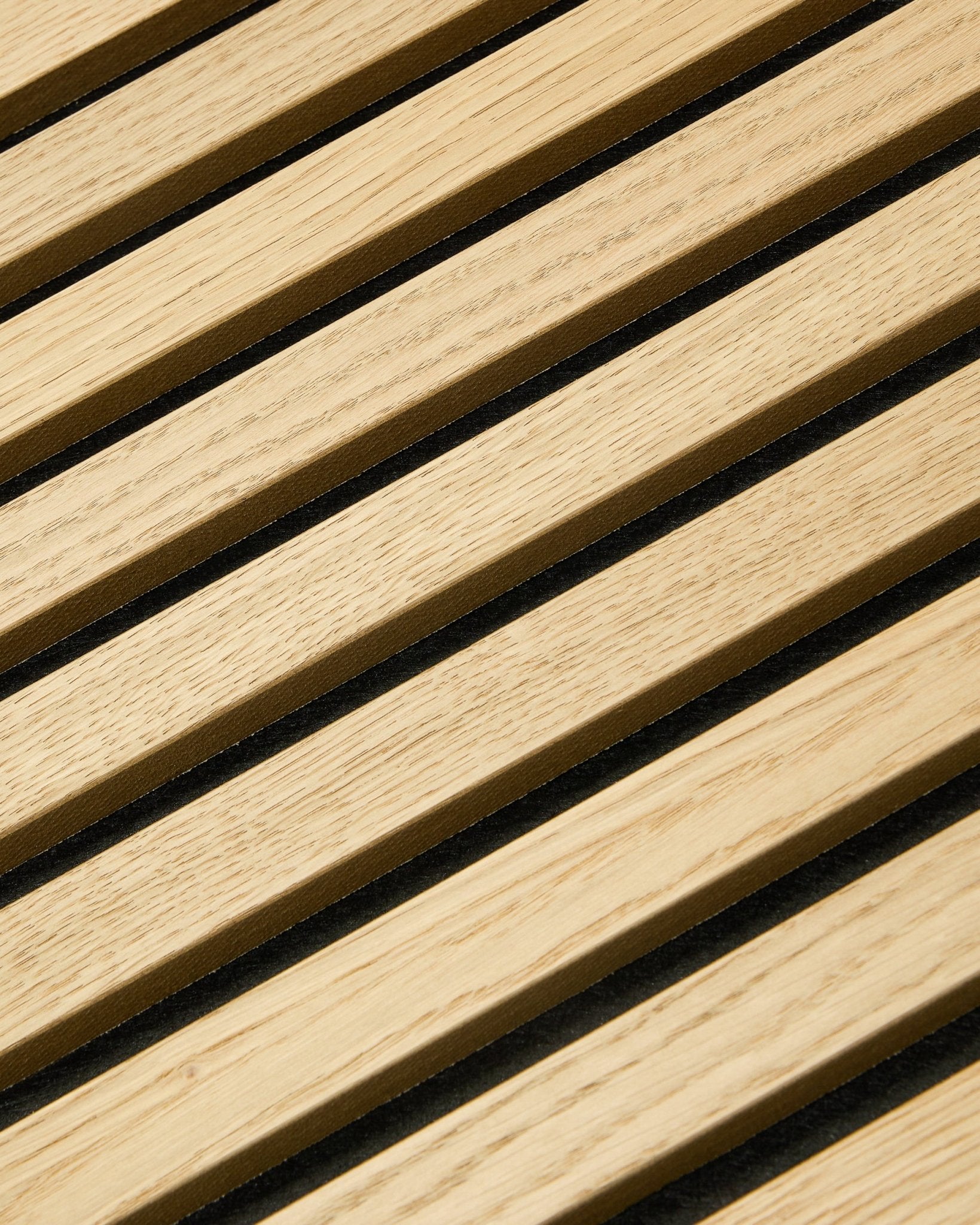 Gros plan sur le panneau WoodUpp Akupixel Classic Oak Panneau acoustique, 60x60 cm, avec des espaces en feutre black entre les lattes en chêne dans un design nordique rayé.