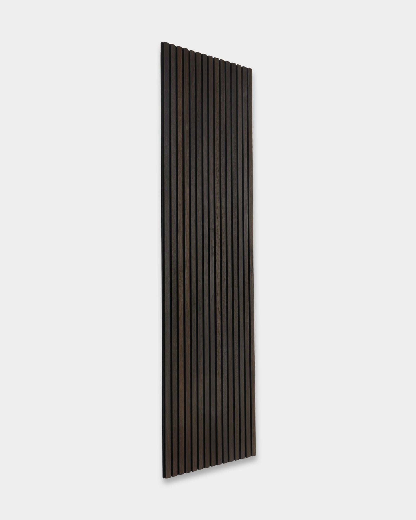 Smoked Oak rustique Akupanel Panneau acoustique de WoodUpp, avec des lattes en bois foncé verticales, appuyé contre un mur gris clair.