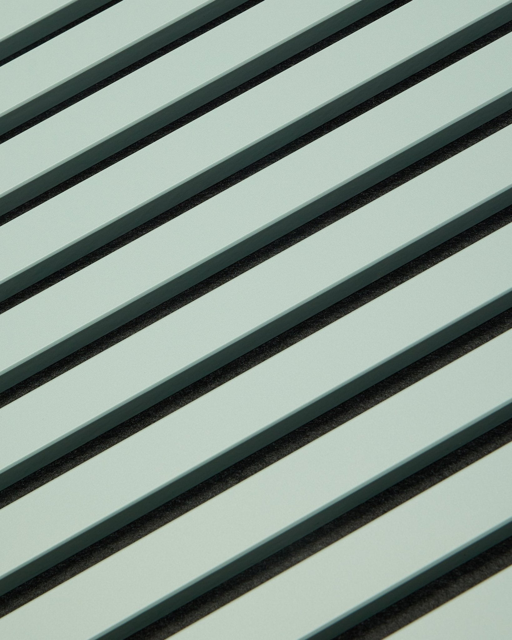 Hue | Akupanel / Cloud de WoodUpp présente des panneaux acoustiques en bois vert clair avec des lattes verticales et des interstices foncés, créant un motif géométrique pensé pour l’absorption sonore.