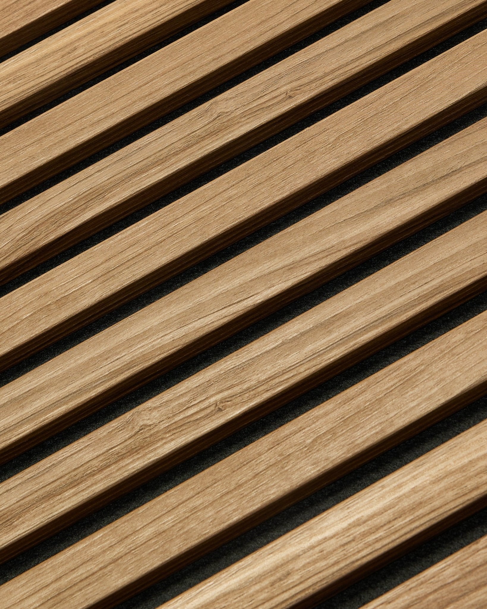 Gros plan en diagonale du Akupanel Essential Panneau acoustique WoodUpp en noyer anglais, 240x60 cm, montrant une finition homogène et un fond sombre entre chaque latte de bois.