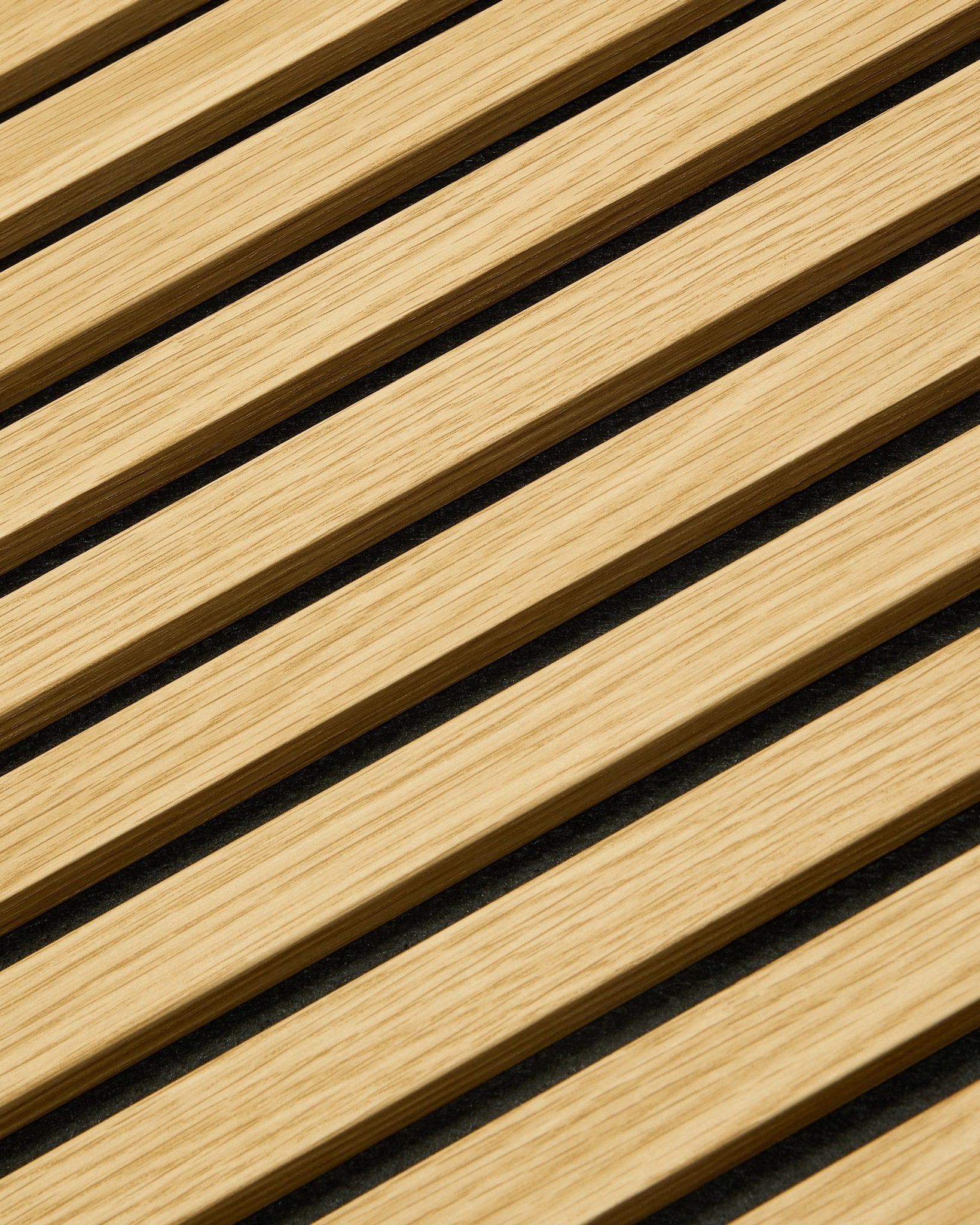 Gros plan sur le panneau WoodUpp Akupanel Panneau acoustique en Southern Oak, 240 x 60 cm, avec des lattes diagonales et des espaces acoustiques foncés pour une meilleure absorption sonore.