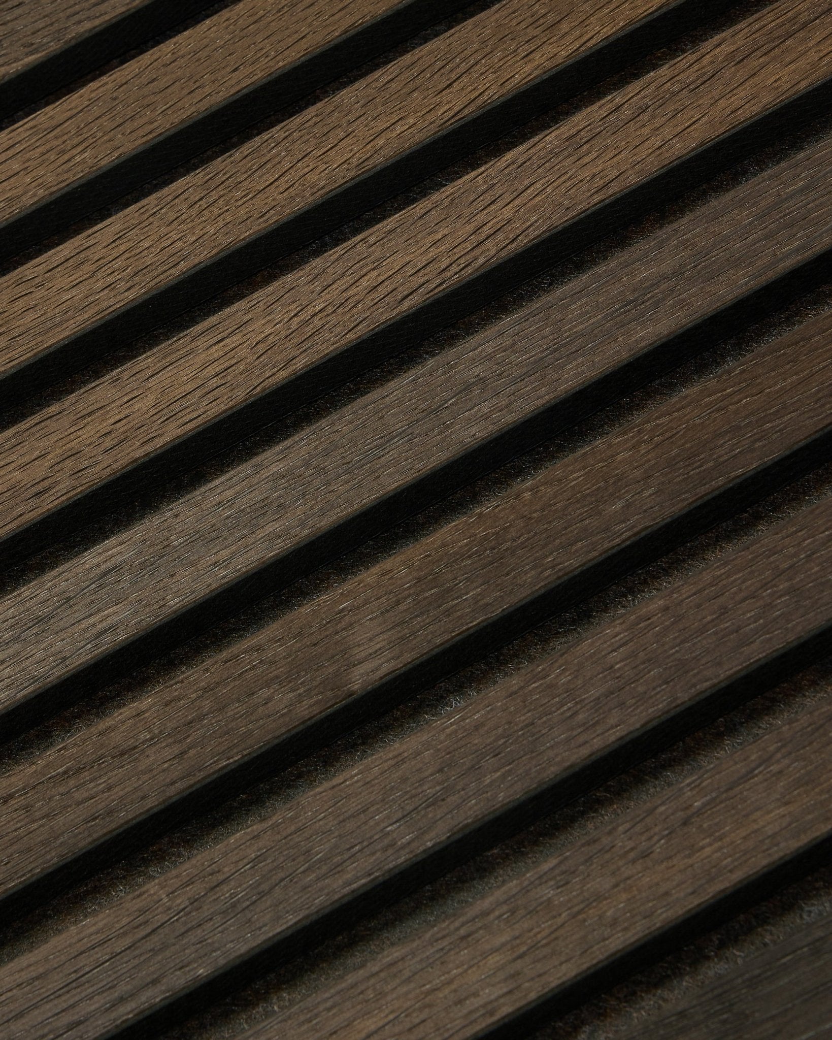 Gros plan sur le panneau Akupanel Panneau acoustique Tonal en Smoked Oak (240 x 60 cm) de WoodUpp, avec des lattes nordiques diagonales et texturées dans un design scandinave.