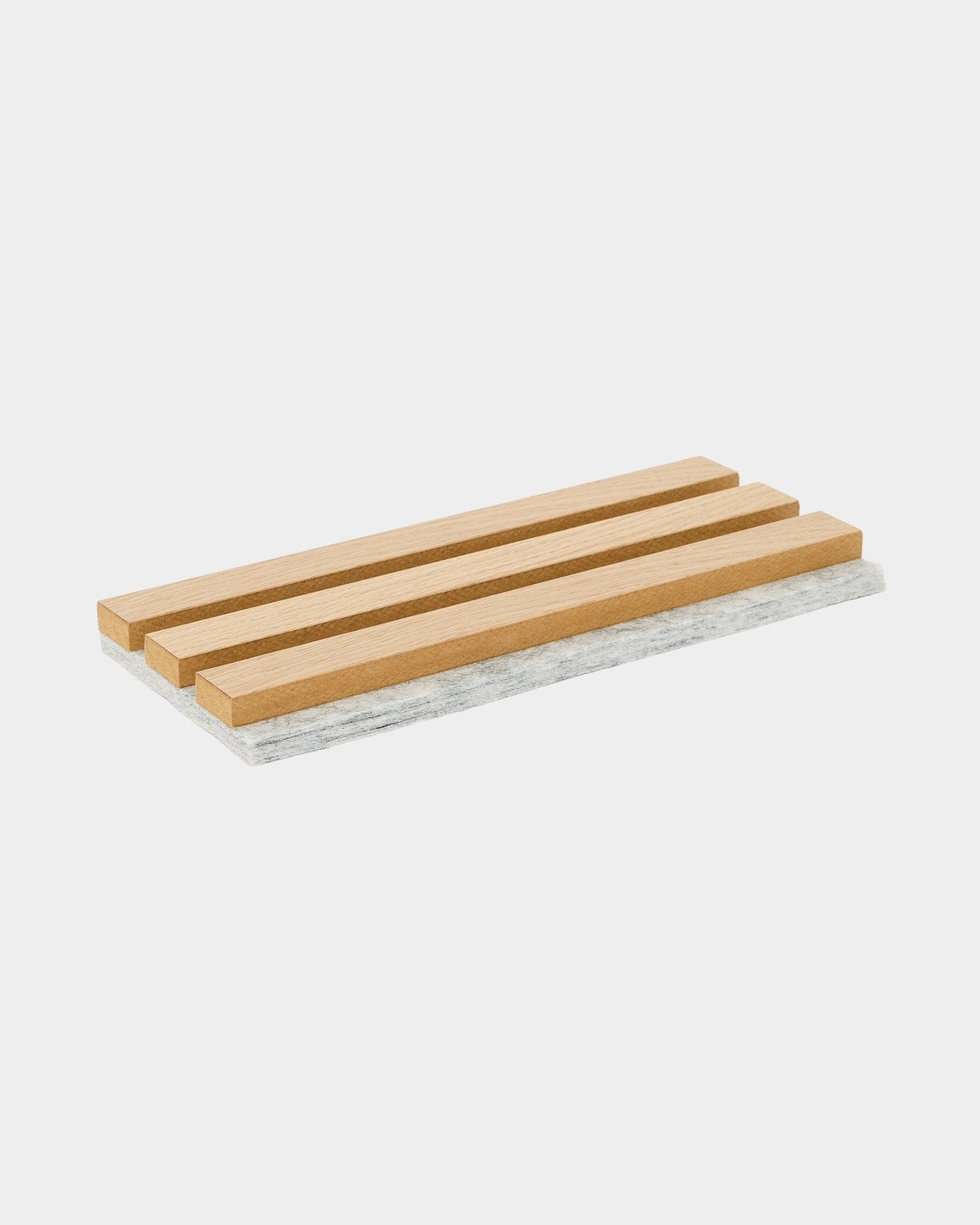 Dessous de plat échantillon WoodUpp Akupanel avec des lattes en chêne classique et un support en feutre gris, conçu pour protéger les surfaces et mettre en valeur le matériau acoustique nordique.