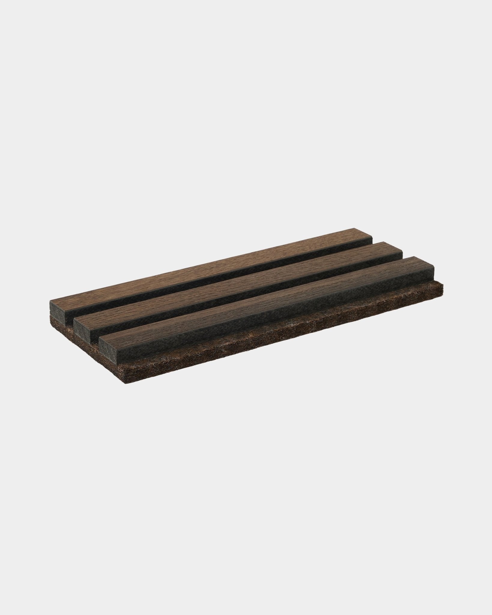 Le porte-savon Tonal de WoodUpp en coloris dark smoked oak, fabriqué en natural wood, présente trois rainures parallèles ; un accessoire conçu pour compléter les collections Akupanel.