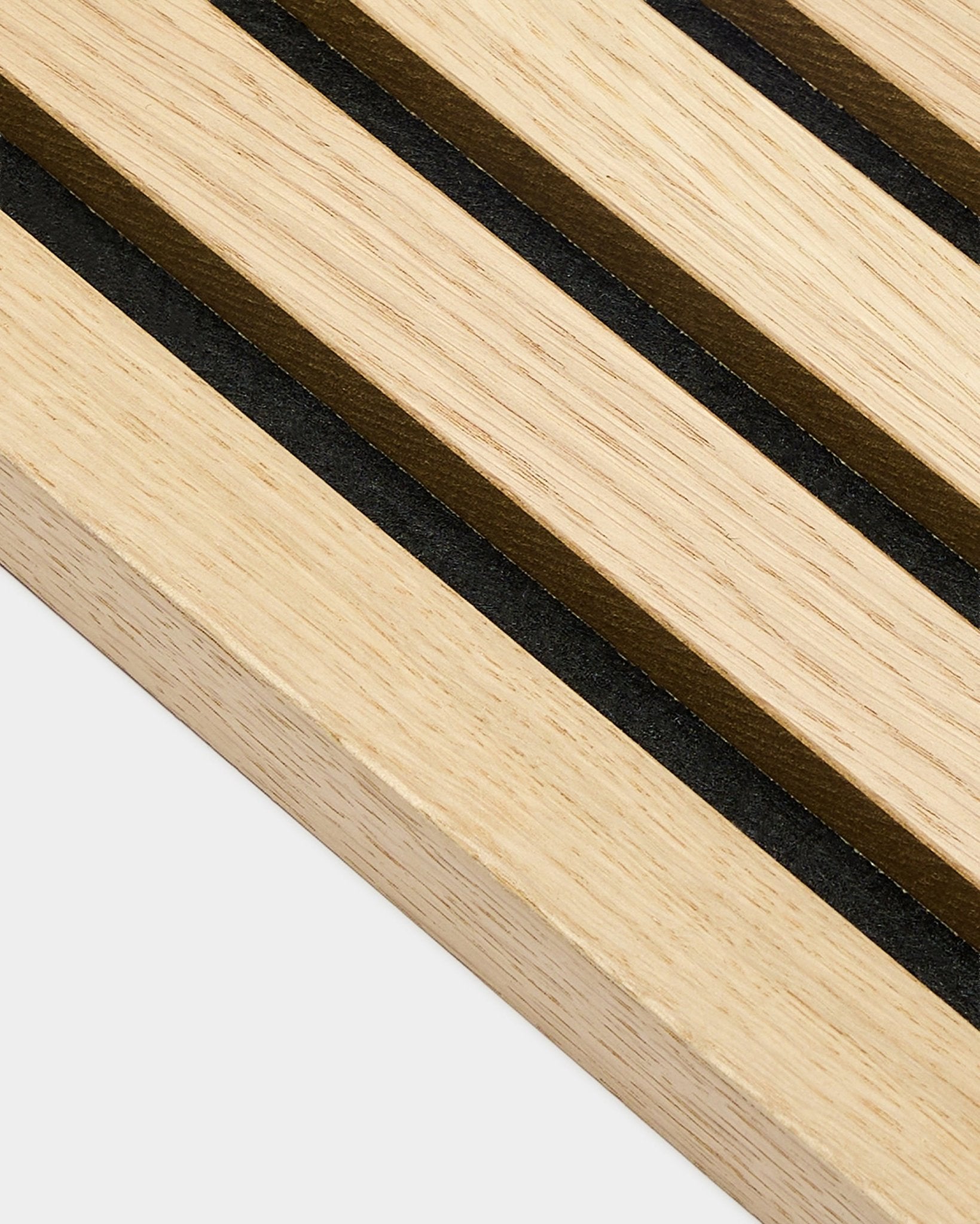 Gros plan sur la lamelle d’extrémité WoodUpp Akupanel Classic Oak, épaisseur 2,2 cm, avec des rayures parallèles black et brown, caractéristiques des panneaux acoustiques nordiques.