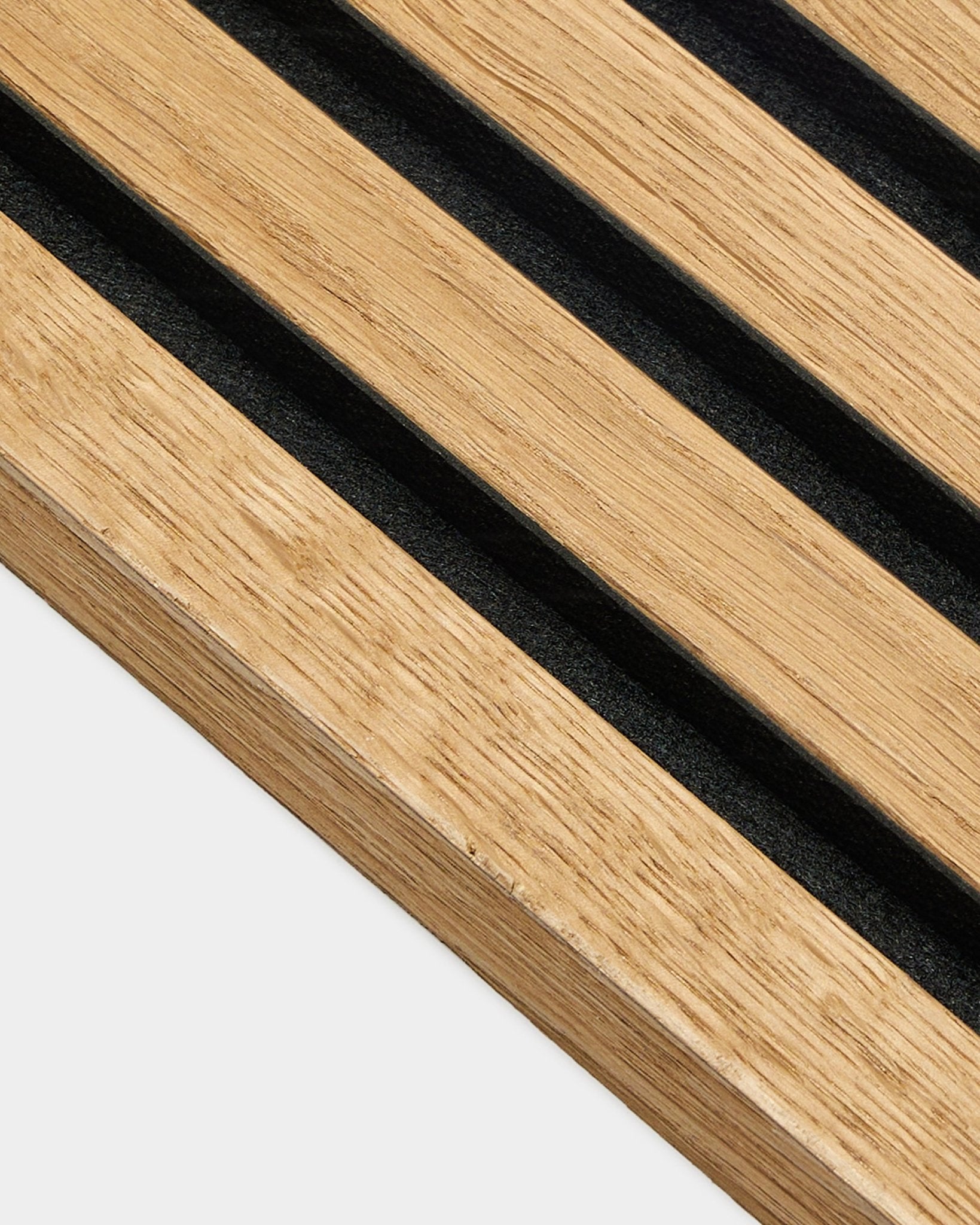 Gros plan sur le panneau lamelle d’extrémité WoodUpp en chêne Rustic Brown (2,2 cm), conçu pour les installations acoustiques Akupanel, avec des lattes régulièrement espacées sur un mur clair.