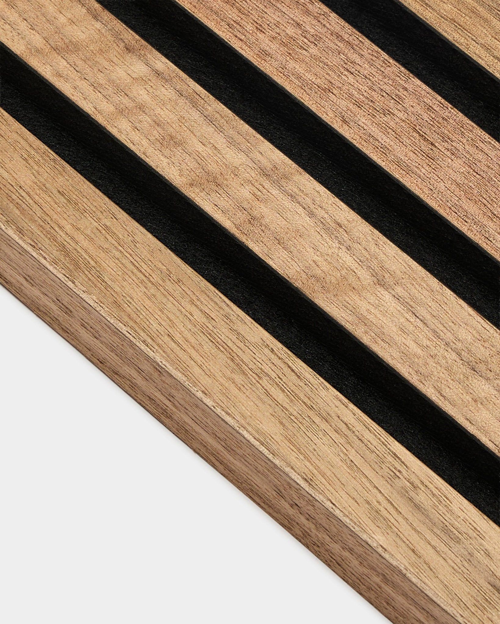 Gros plan sur la lamelle d’extrémité WoodUpp Akupanel en noyer, Panneau acoustique de 2,2 cm avec des rayures parallèles black et le veinage visible du noyer, sur fond blanc.