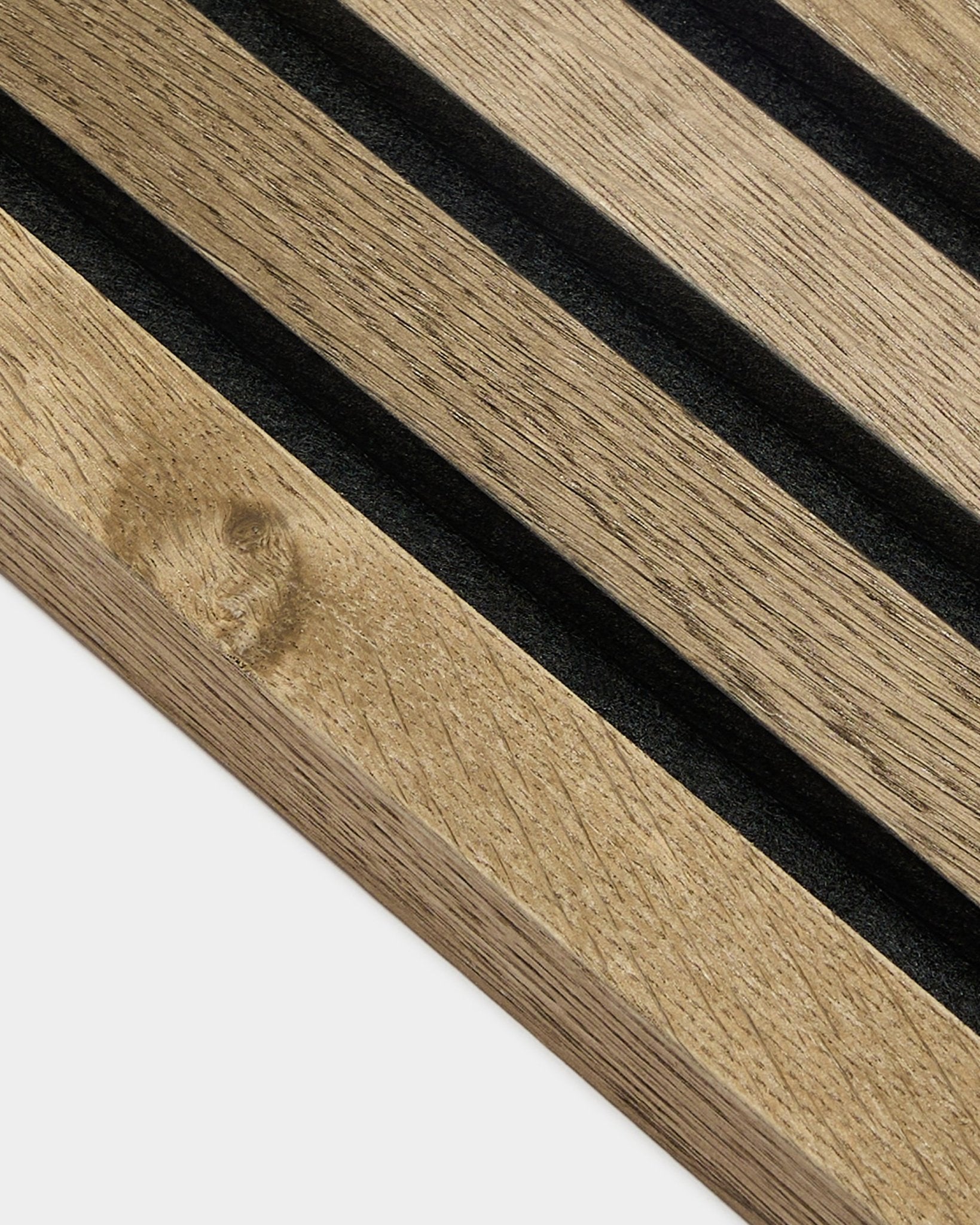 Gros plan sur la lame de finition WoodUpp Akupanel en Rustic Grey Oak, Panneau acoustique en MDF de 2,2 cm avec rainures black et veinage du bois visible sur fond gris clair.