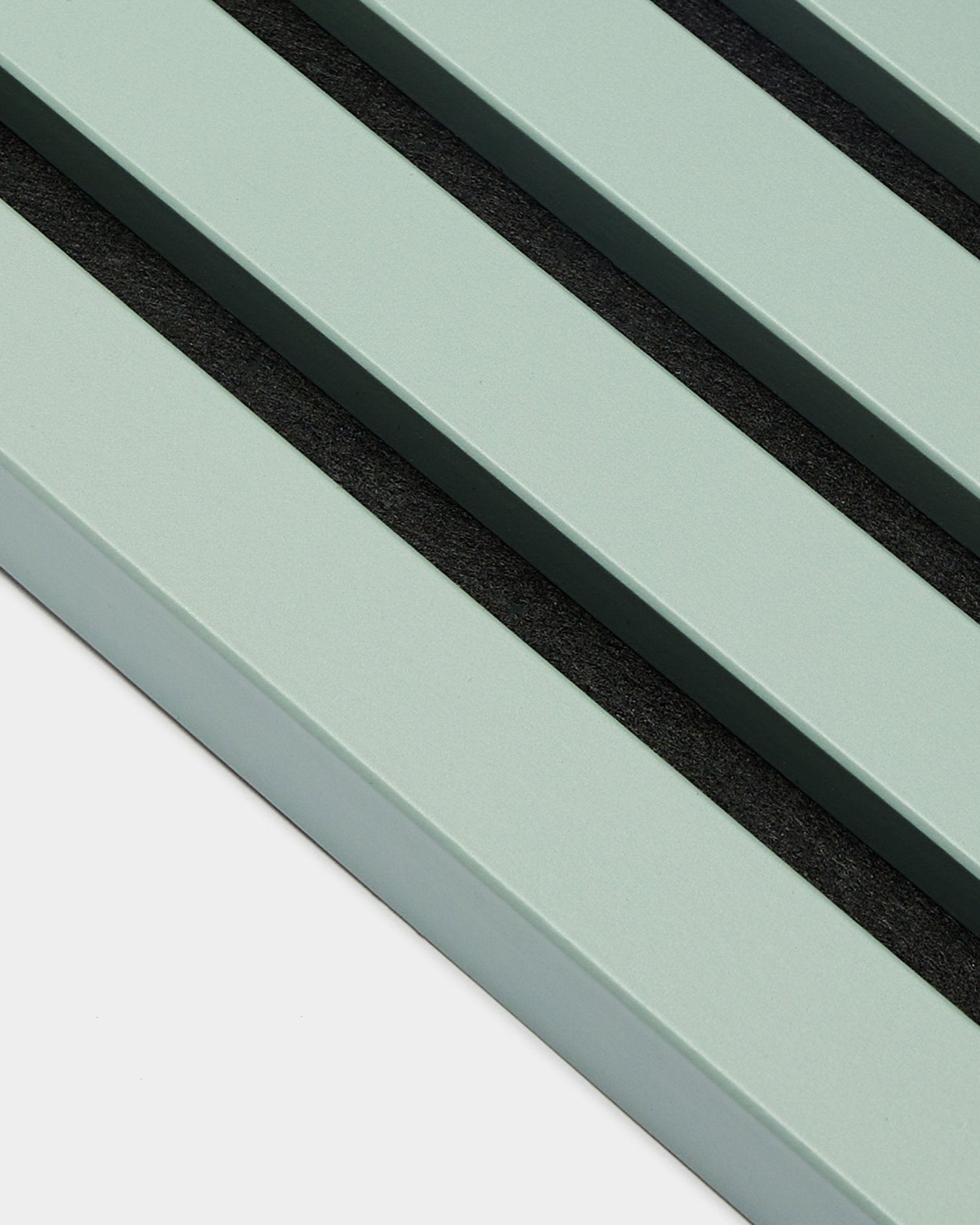 Gros plan sur trois lattes End Lamella / Cloud vert pastel parallèles, de 2,2 cm de large, signées WoodUpp, intégrées à un Akupanel Panneau acoustique sur fond clair.