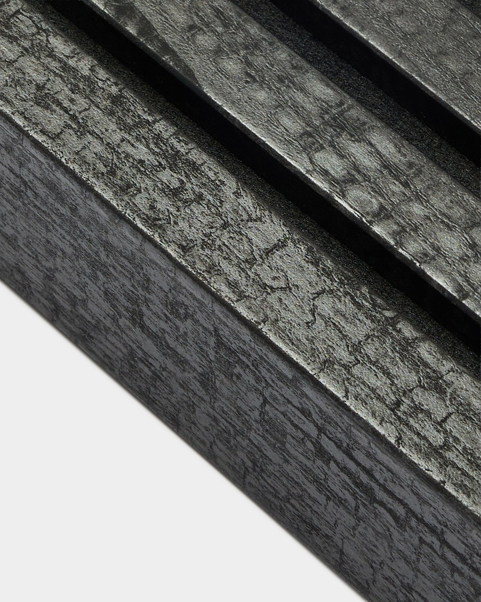 Gros plan de la lamelle de finition WoodUpp Akupanel en Charcoal, largeur 6,7 cm, avec lattes acoustiques parallèles et texture de veinage du bois distinctive.