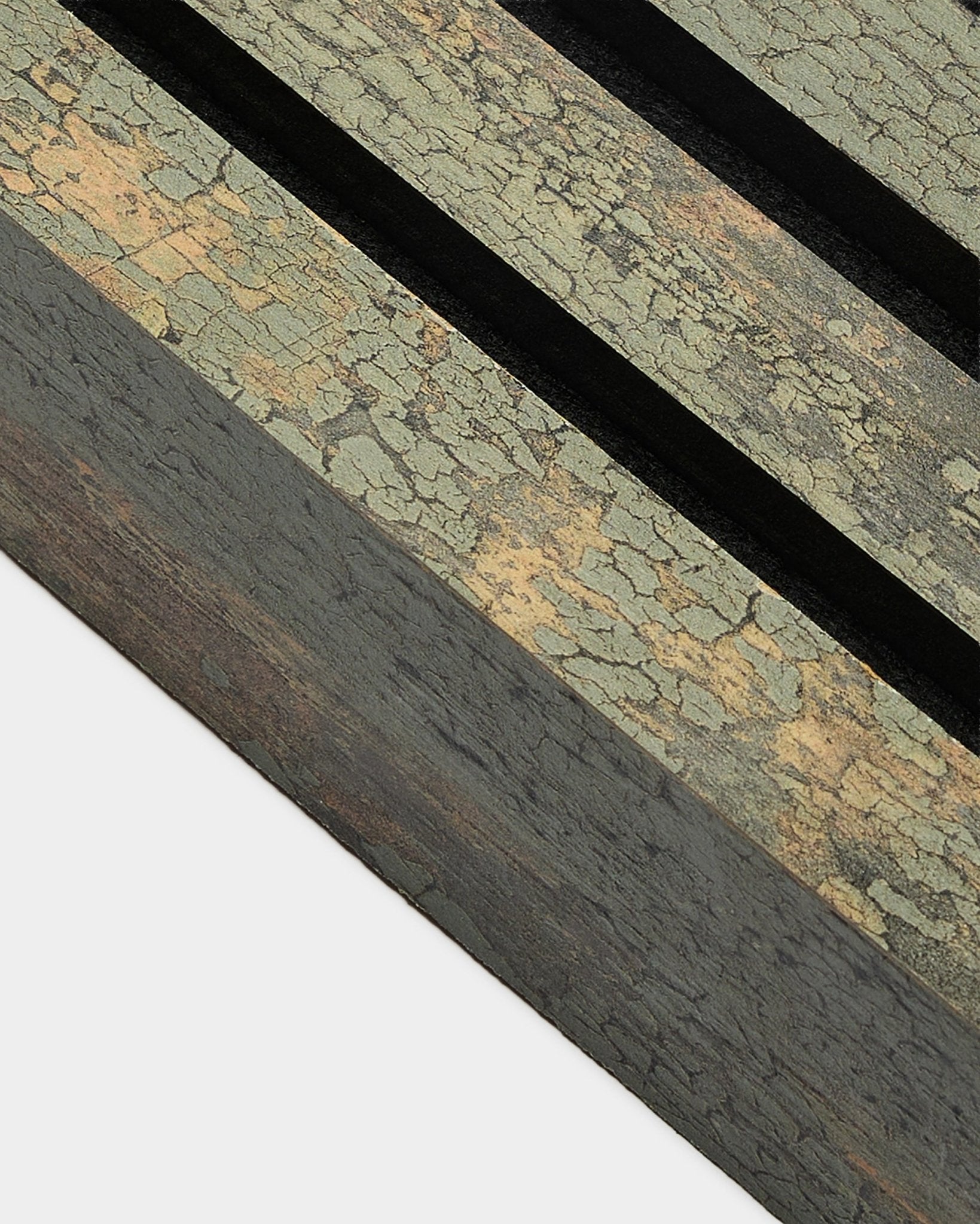 Gros plan sur la lamelle d’extrémité WoodUpp Akupanel en Oxide Grey, large de 6,7 cm, avec un Panneau acoustique texturé, deux rainures black et un cadre en MDF.