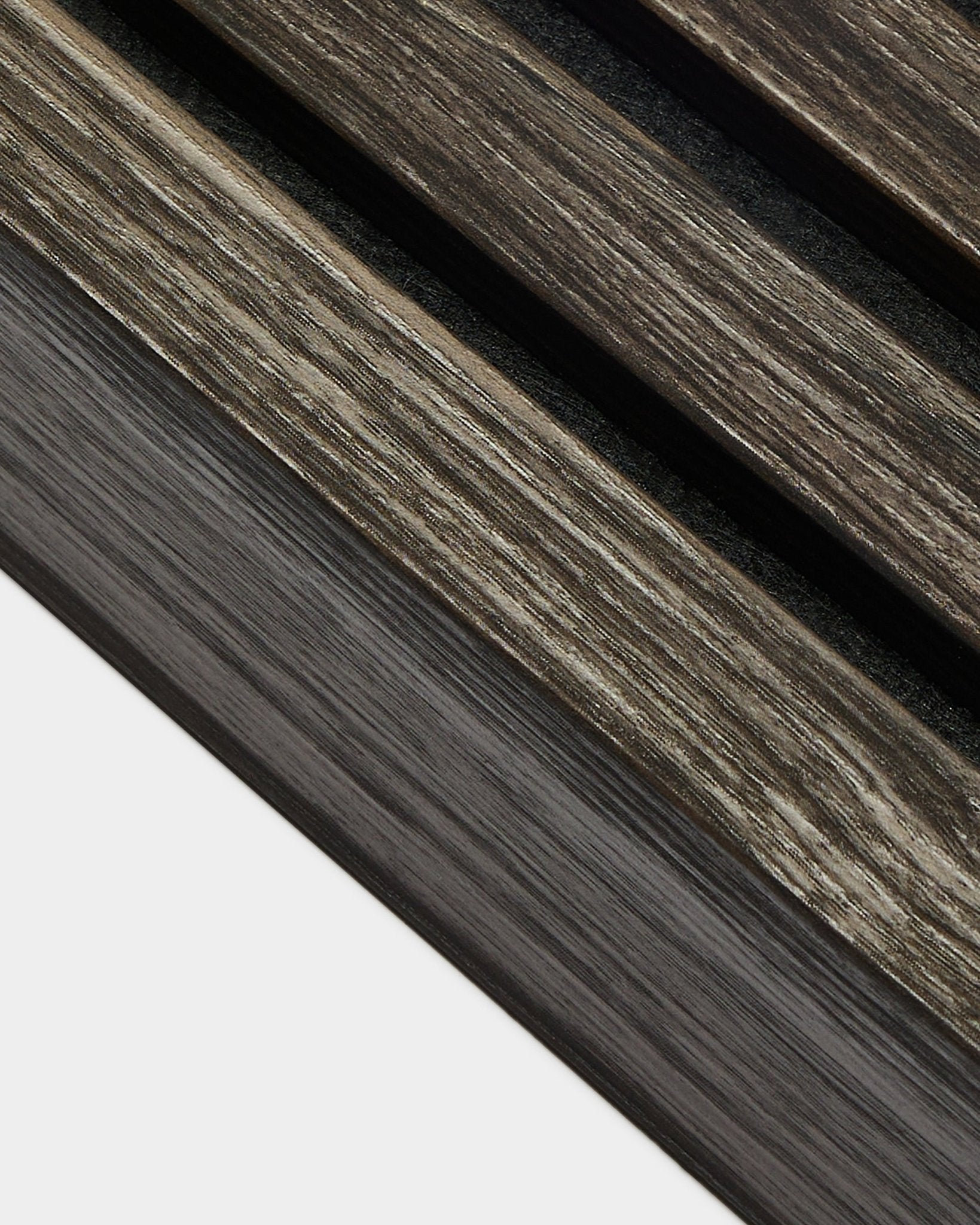 Gros plan sur un détail d’installation de WoodUpp Akupanel en Black Oak, avec des lamelles de finition de 6,7 cm disposées en diagonale et des bords de panneau finis sur un fond clair.