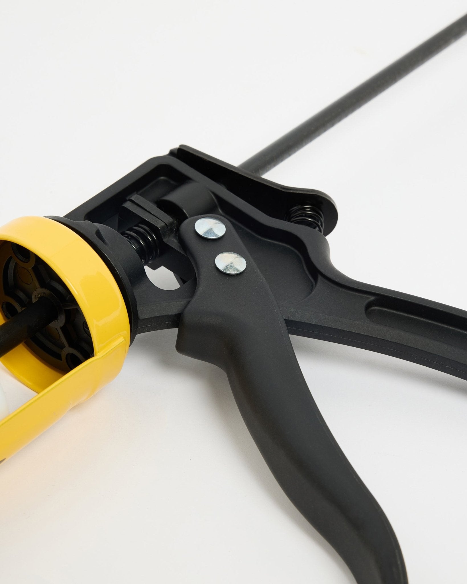 Gros plan sur le pistolet à mastic WoodUpp black et jaune (290 ml), un accessoire CREATE pour l’installation des Akupanel Panneau acoustique, présenté sur une surface blanche.