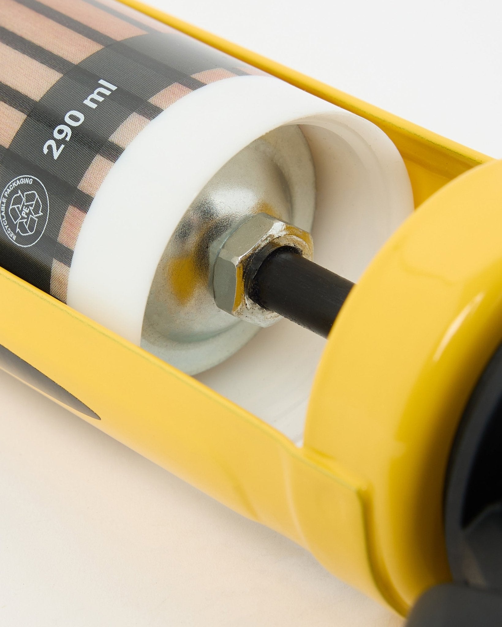 Vue détaillée du pistolet à mastic WoodUpp (290 ml), un outil d’installation jaune avec des composants métalliques, utilisé pour monter des panneaux acoustiques et des séparateurs de pièce.