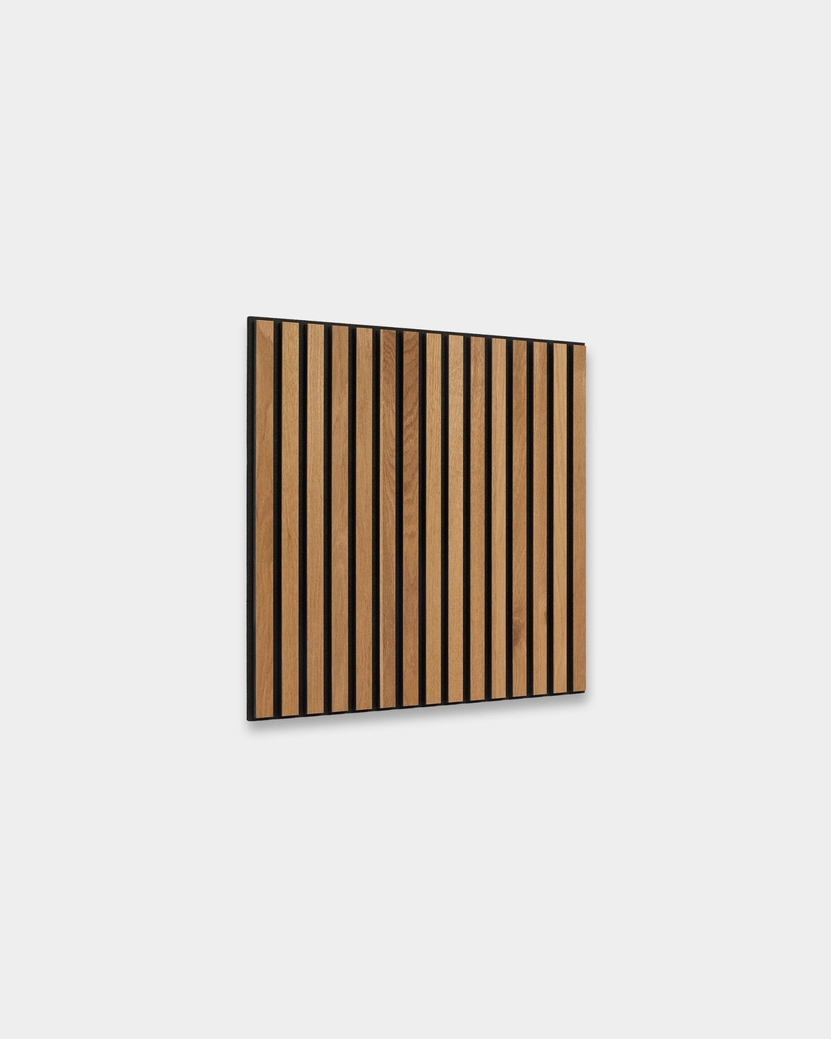 WoodUpp Akupixel Rustic Brown Oak 60x60cm Panneau acoustique avec des lattes verticales et des interstices black, présenté contre un mur intérieur nordique gris clair.