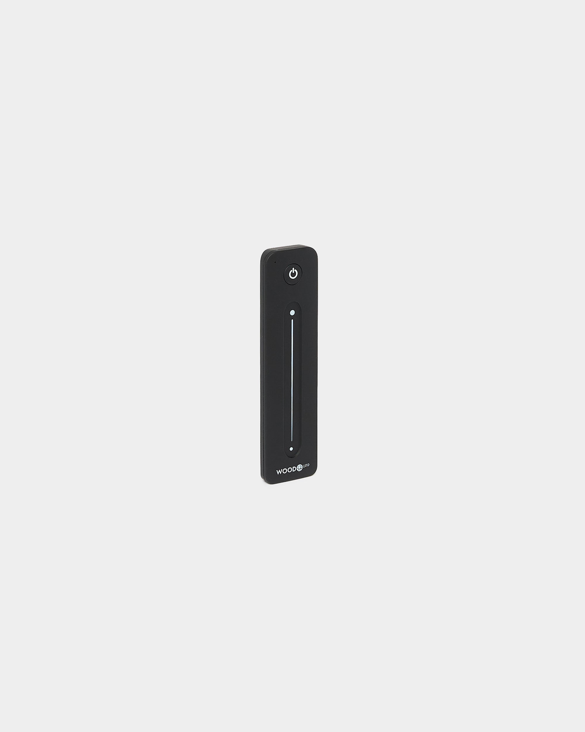 Télécommande WoodUpp black Lumi fine pour rubans LED, avec curseur tactile vertical et bouton d’alimentation, compatible Philips Hue, présentée sur fond blanc.