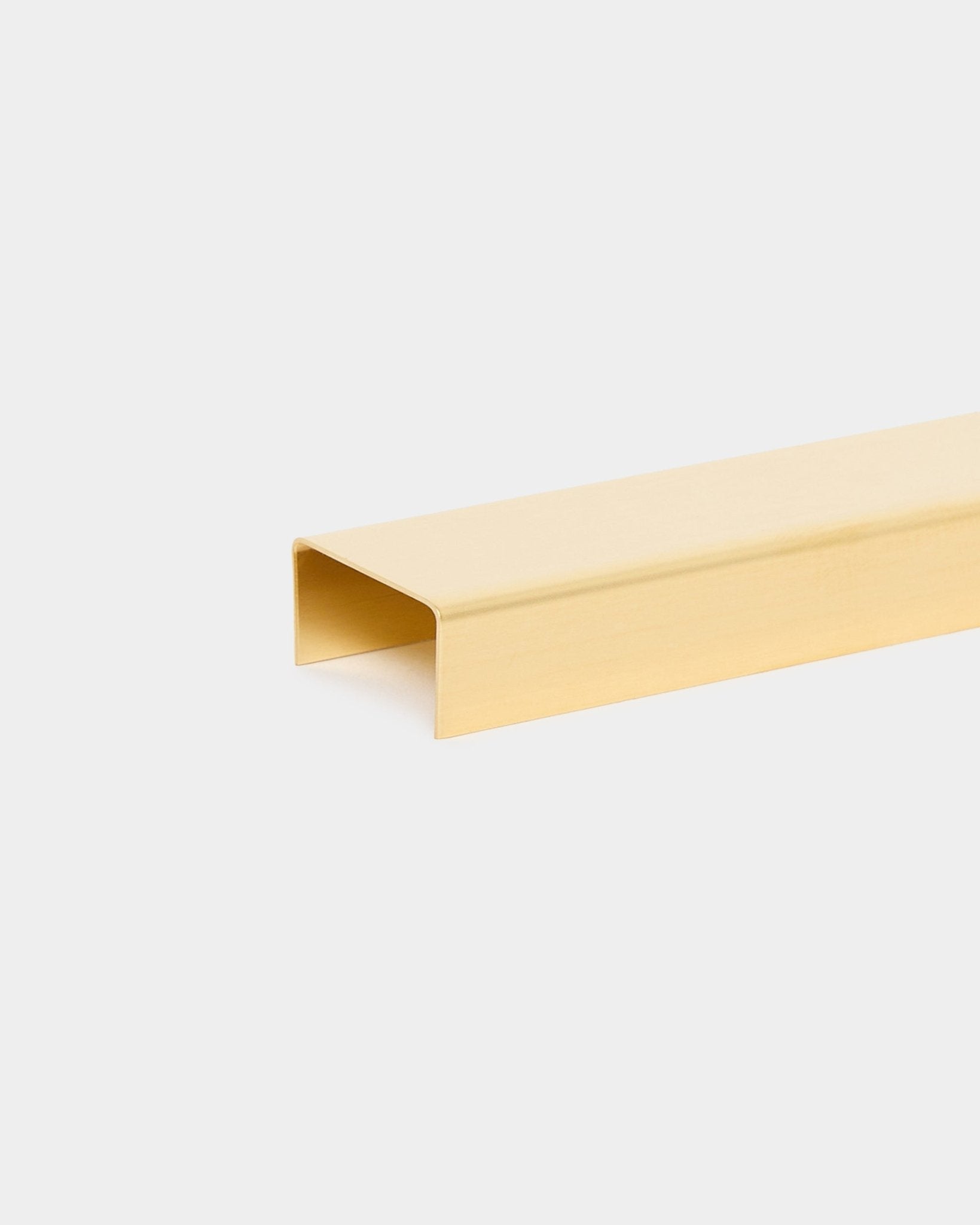 Das Liva Cover in brass, 20 cm, von WoodUpp ist ein goldfarbener U-förmiger Metallkanal, der als Abschlussprofil für Akupanel Akustikholzpaneele konzipiert ist.