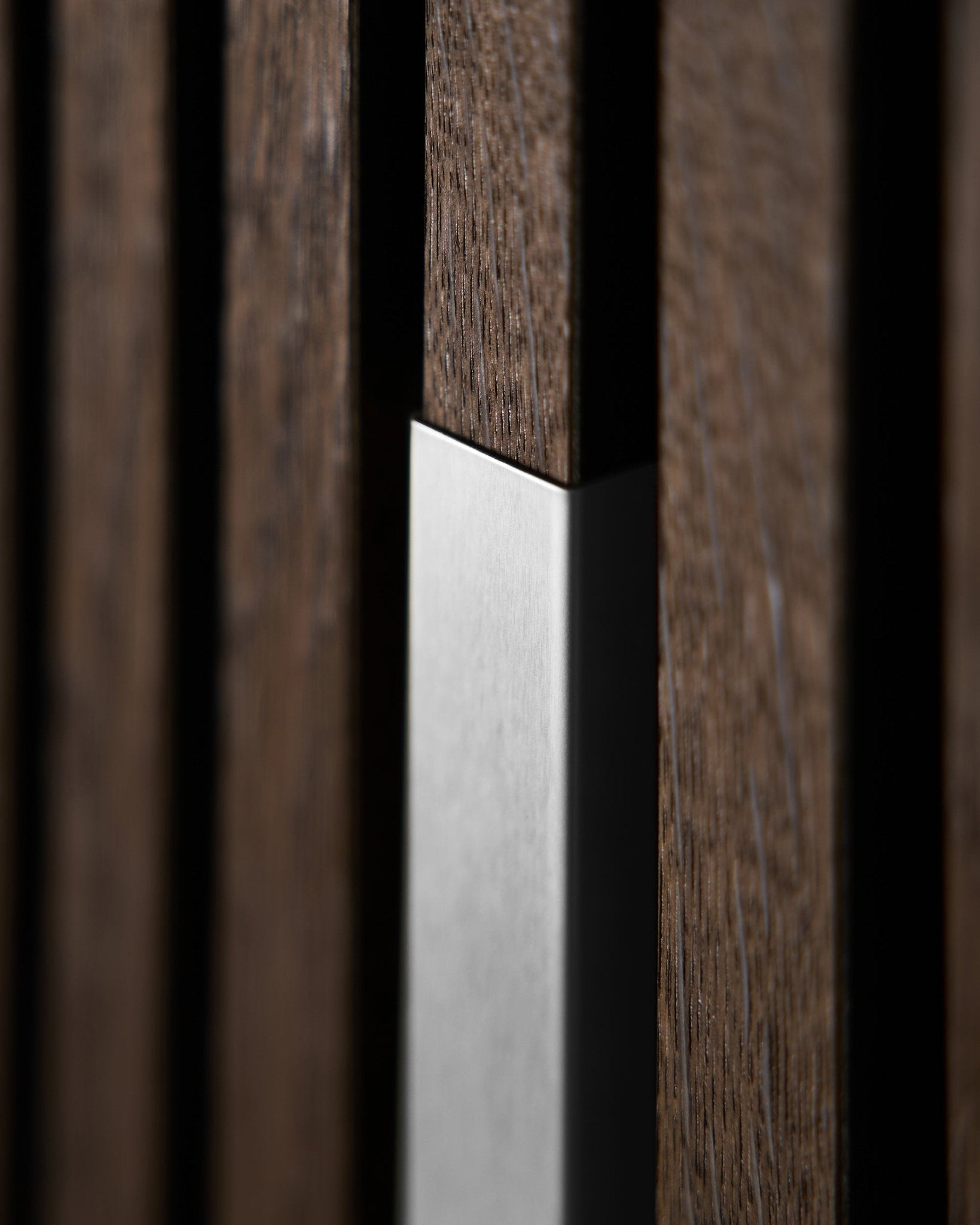 Gros plan sur WoodUpp Akupanel Liva | Cover—20 cm en steel poli avec des lattes de bois vertical, mettant en valeur la texture nordique et le contraste de cet Panneau acoustique.