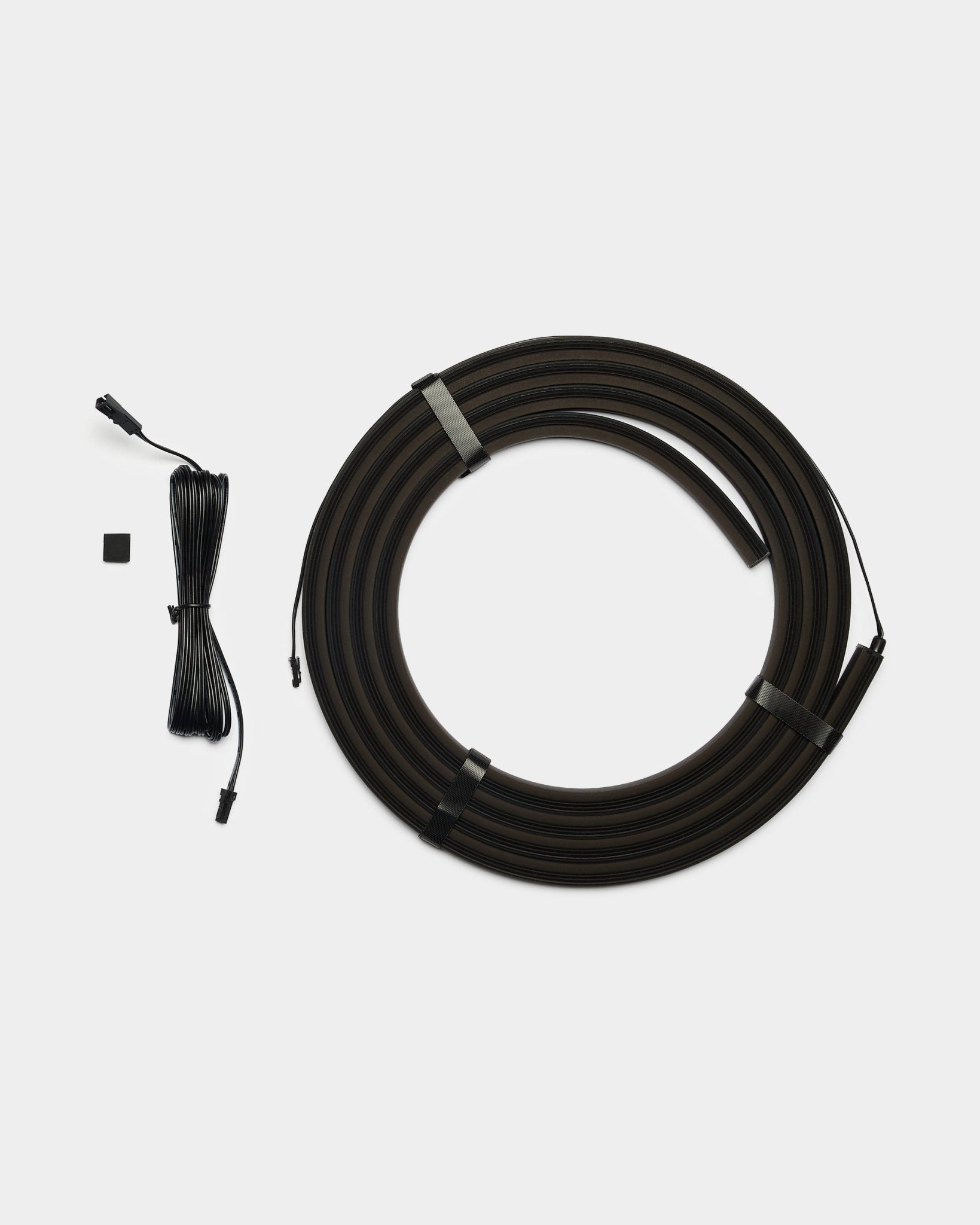 WoodUpp Lumi 300cm bande LED black avec connecteurs, compatible Philips Hue, inclut un long câble black et une small pièce de connexion rectangulaire black.