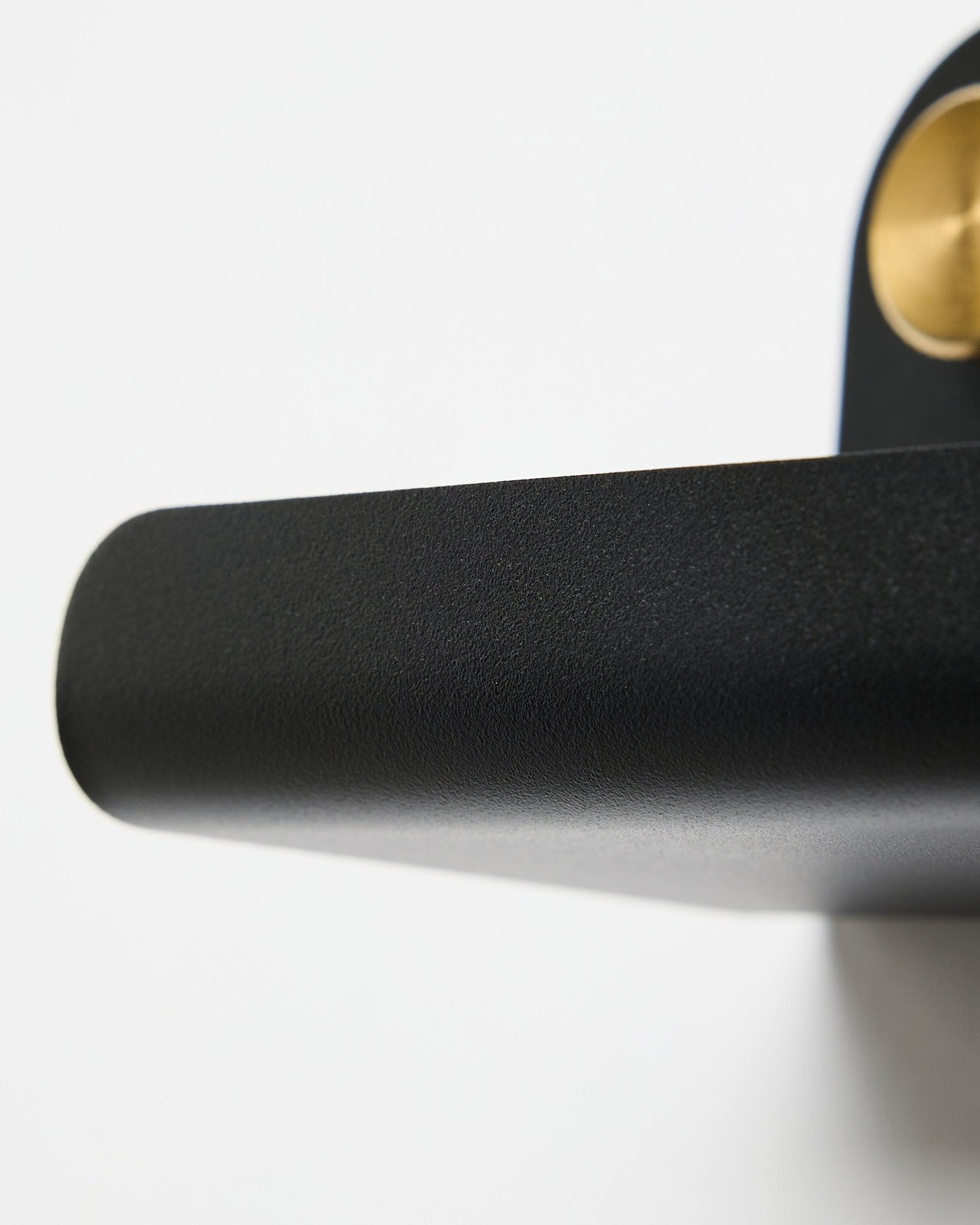 Gros plan sur une poignée de porte black et l’étagère WoodUpp Norr | Narrow Shelf en black, 51,9 cm, placées sur un fond blanc.