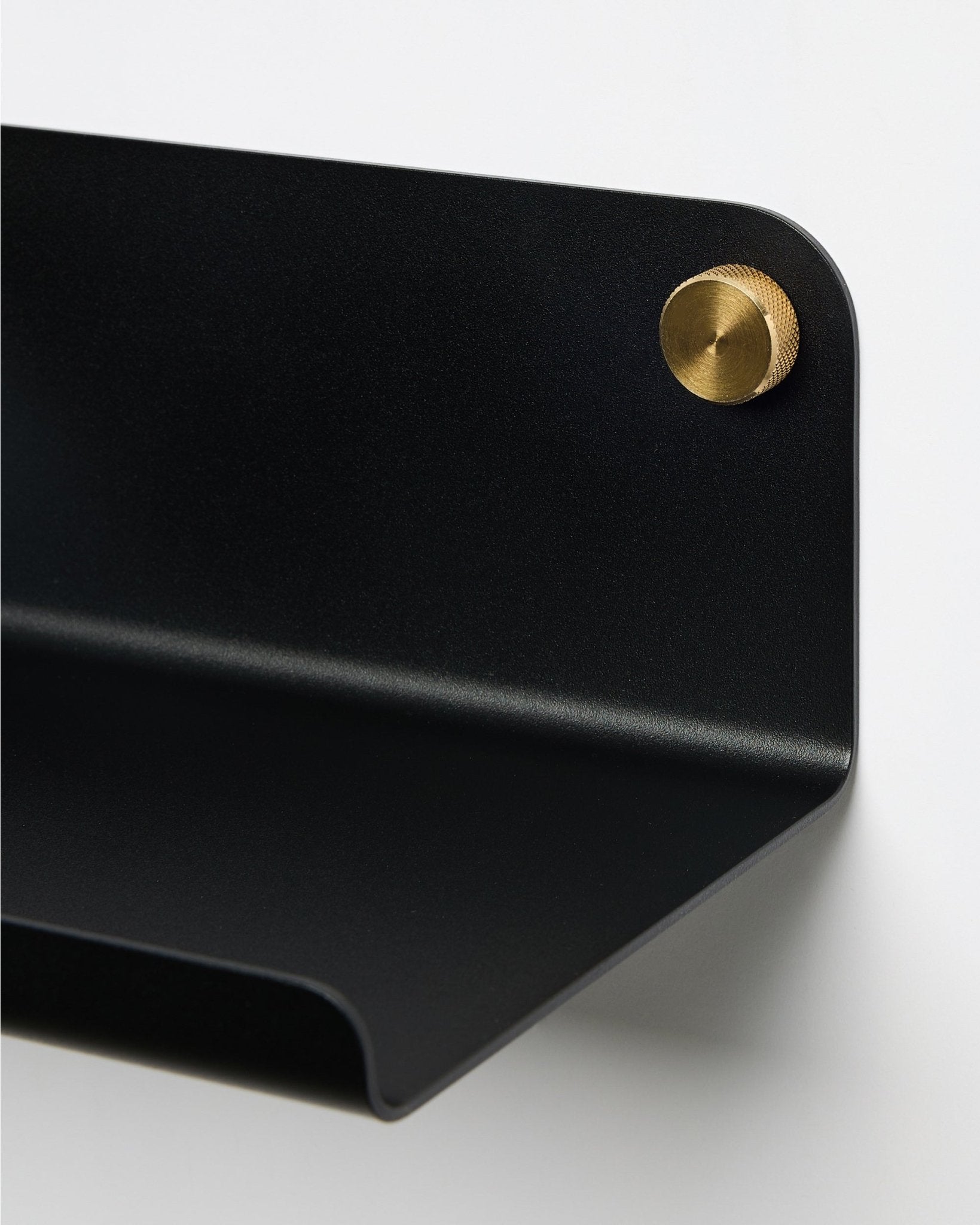 Gros plan sur l’étagère large WoodUpp Norr en black, 35,9 cm, avec un bord incurvé, fixée au mur à l’aide d’une vis ronde en brass. Design nordique minimaliste.