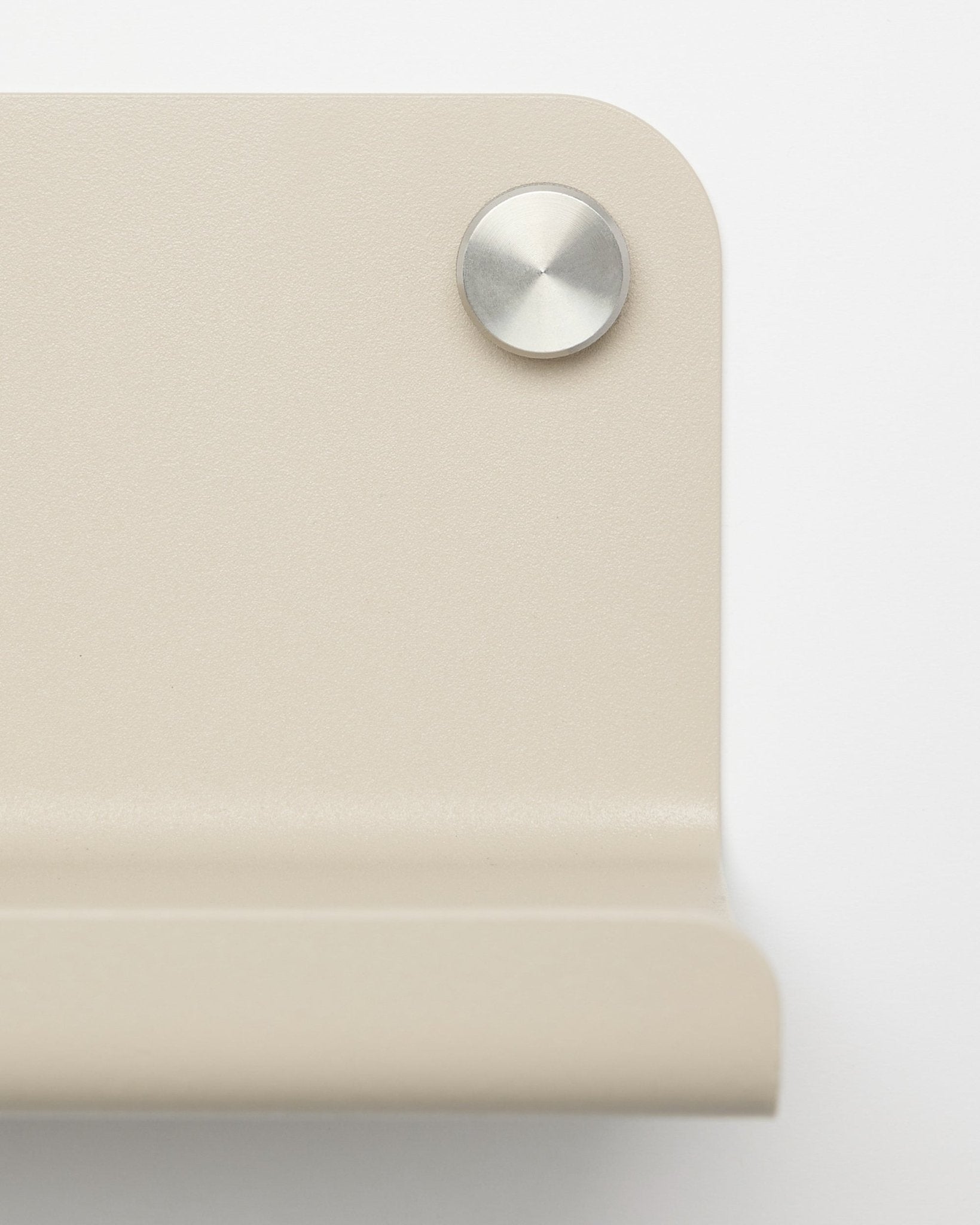 Gros plan sur une équerre d’angle en métal beige avec une vis argentée ronde, conçue pour l’étagère large WoodUpp Norr, 35,9 cm, photographiée sur fond blanc.