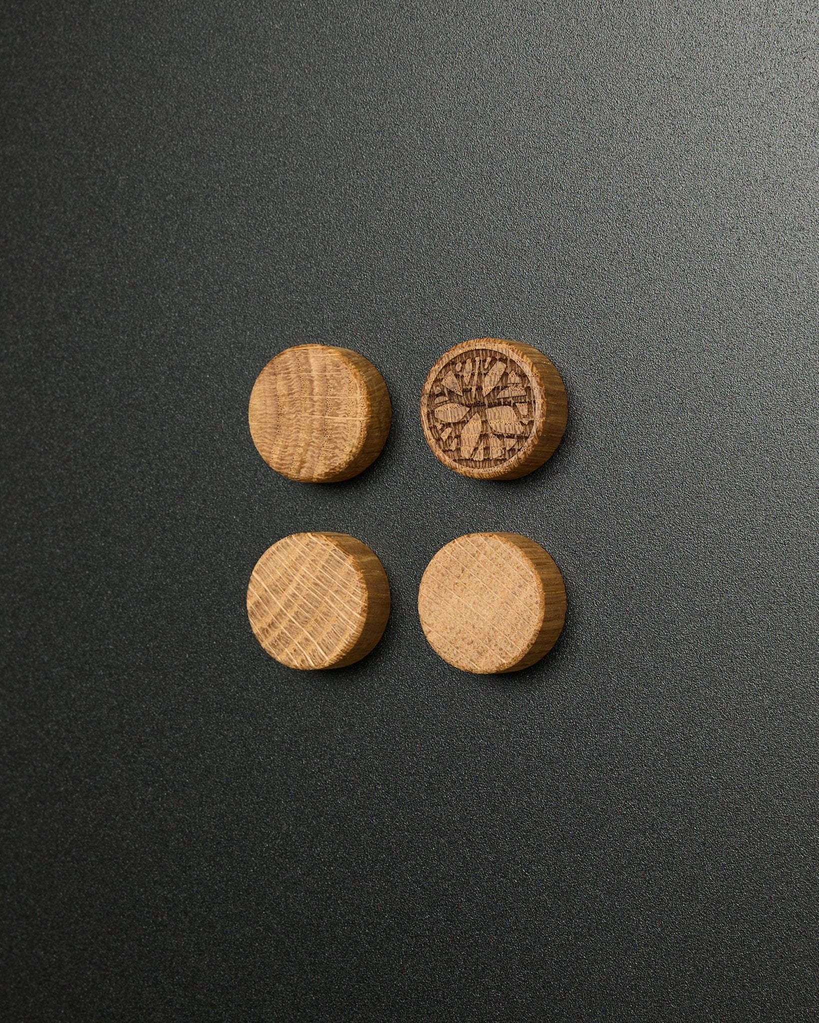 Set aus vier massiven Magneten aus natural oak von WoodUpp, davon einer mit eingraviertem Zitrusscheiben-Design, konzipiert für die Verwendung mit dem Norr Magnetic Board Akustikpaneel.