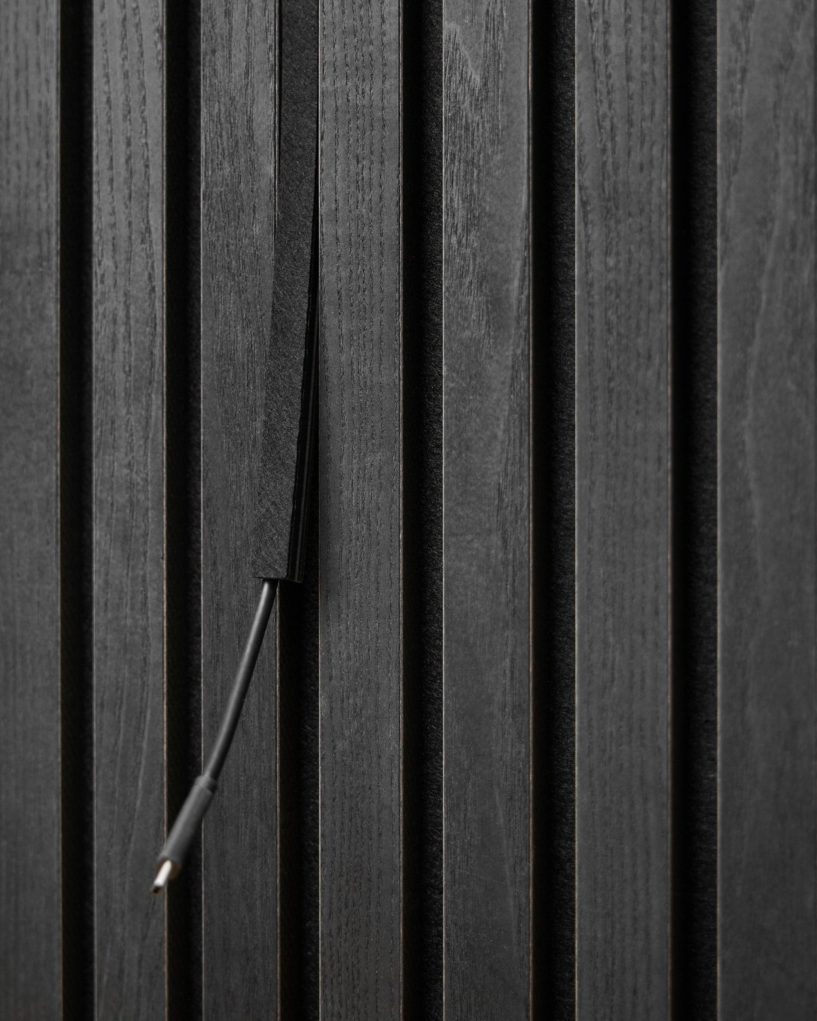 Le cache-câbles Pop-on Dupps (Black, 3 pcs) de WoodUpp dissimule les câbles entre les lattes du Akupanel Panneau acoustique pour un rendu net et intégré.
