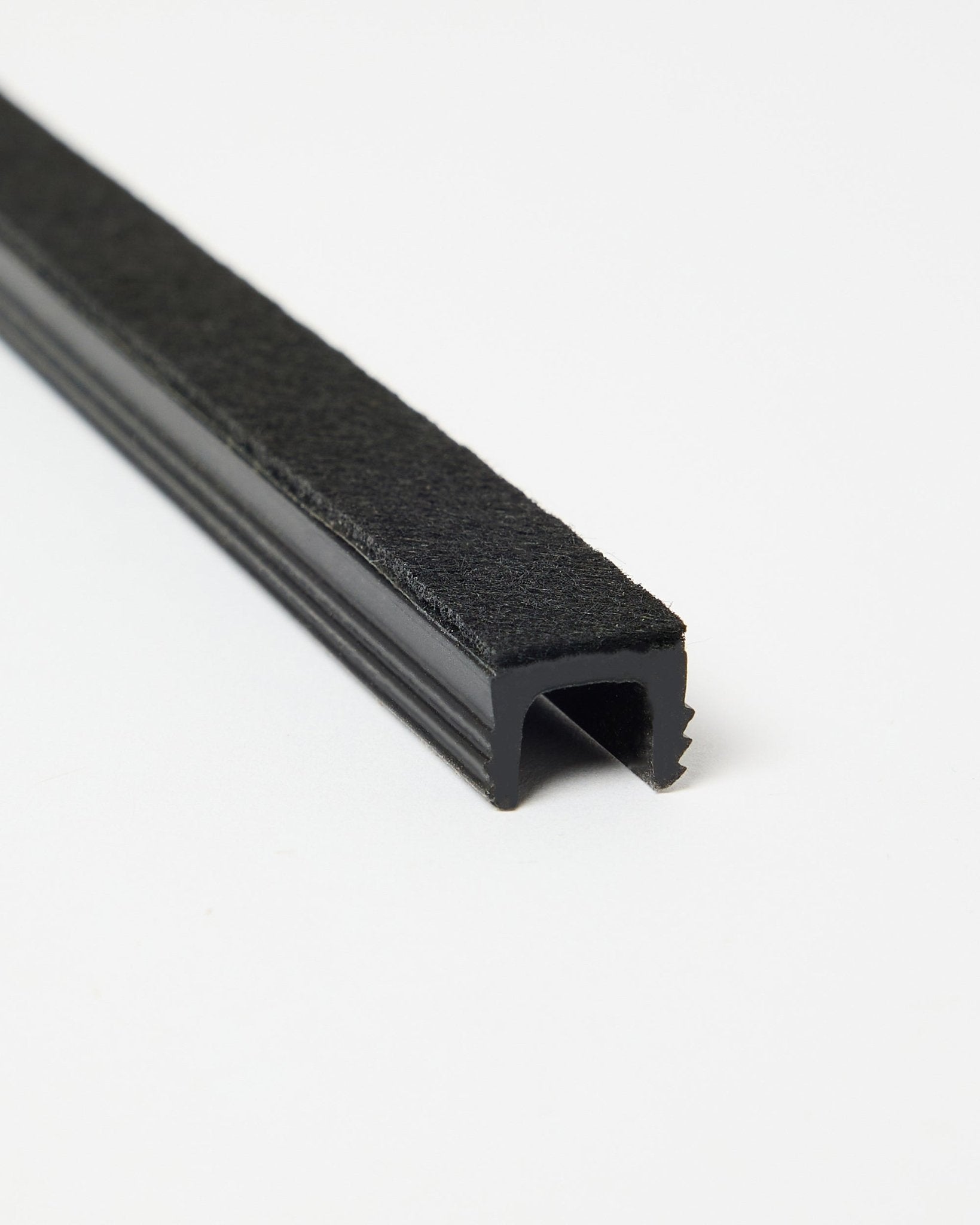 Drei black Dupps Pop-on-Kabelabdeckungen von WoodUpp, auf weißem Hintergrund angewinkelt dargestellt, um Form und Oberfläche zu zeigen. Zubehör für Akupanel-Systeme.