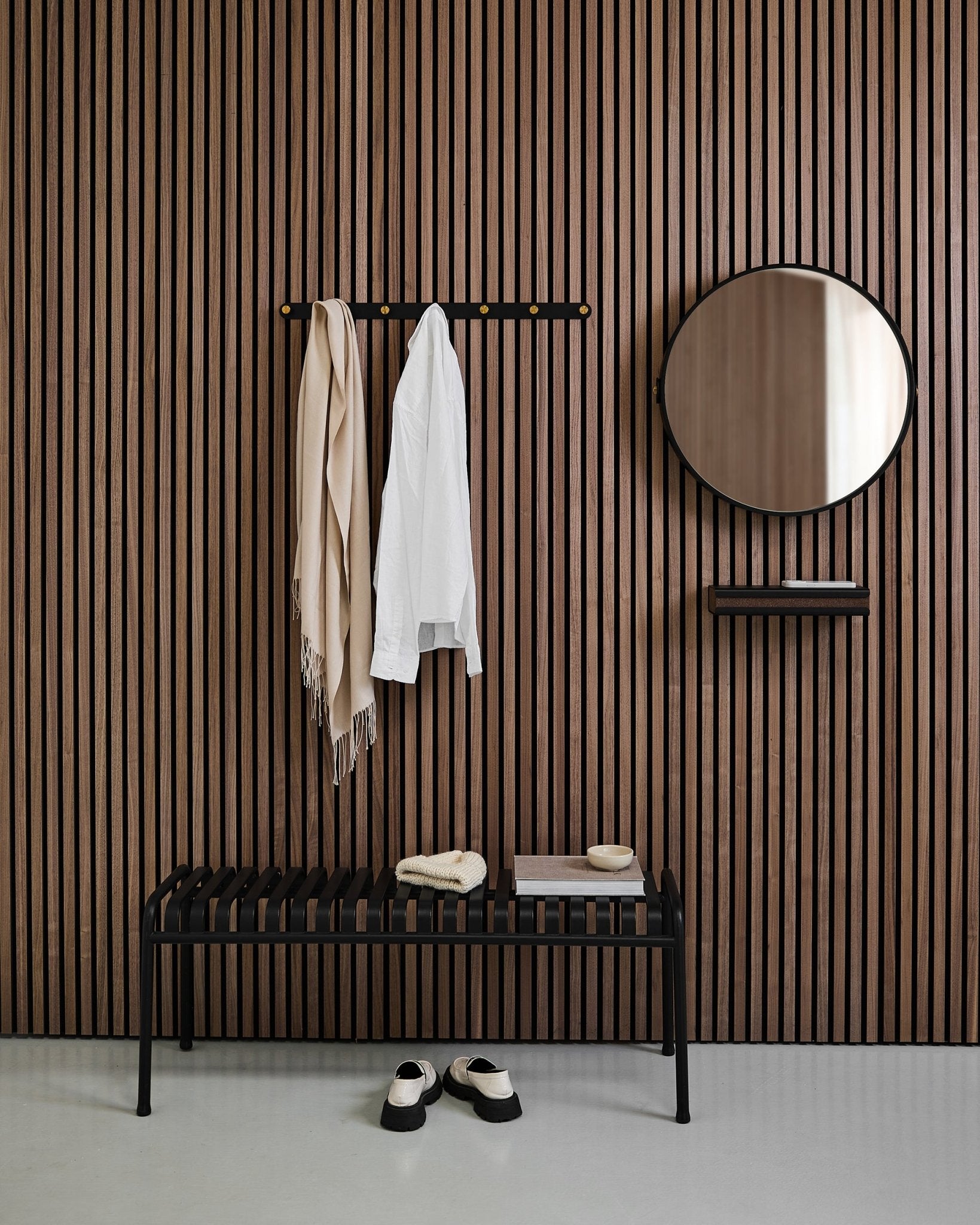 Entrée minimaliste avec un WoodUpp Linn | Mirror en Black Oak, panneau mural acoustique nordique à lattes, banc, étagère, manteau et écharpe suspendus, et chaussures au sol.