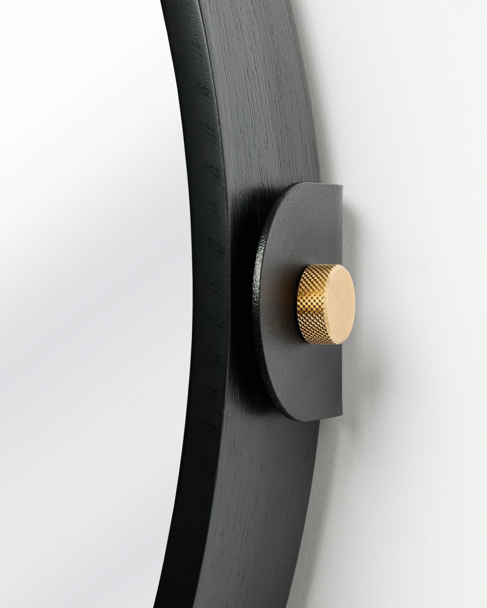 Détail du Linn | Mirror / Black Oak Panneau acoustique de WoodUpp, monté au mur avec un bouton doré et une inclinaison réglable.