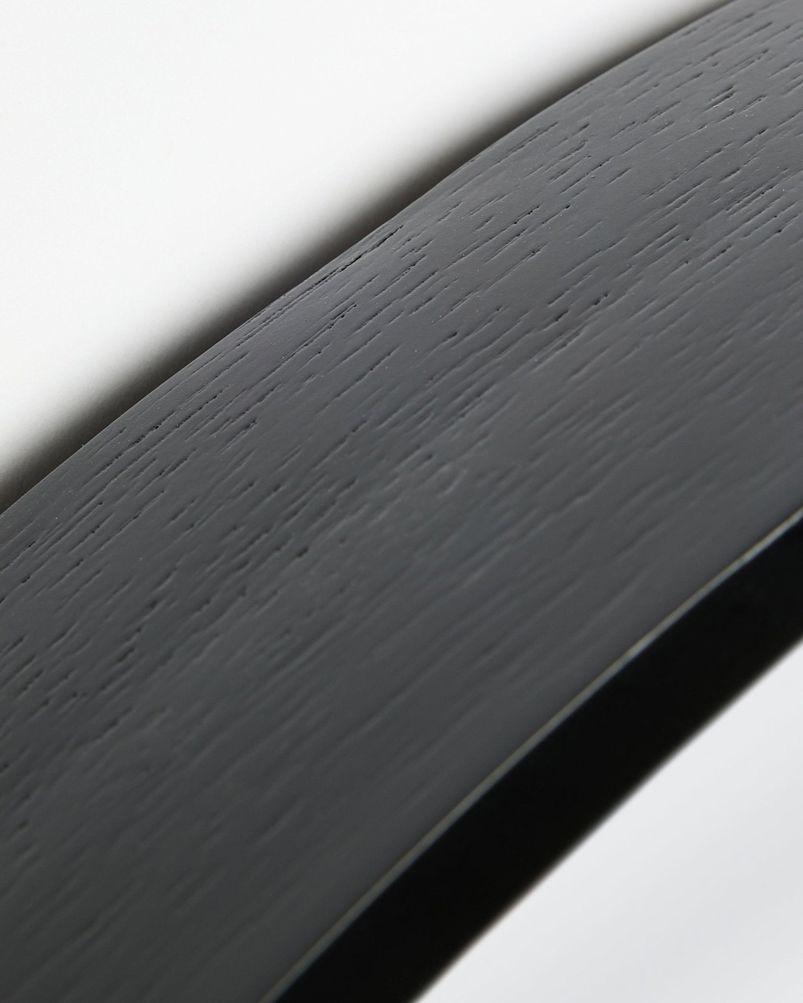 Gros plan du Linn | Mirror / Black Oak Panneau acoustique de WoodUpp, avec une surface courbe et un cadre en black oak, sur fond blanc.