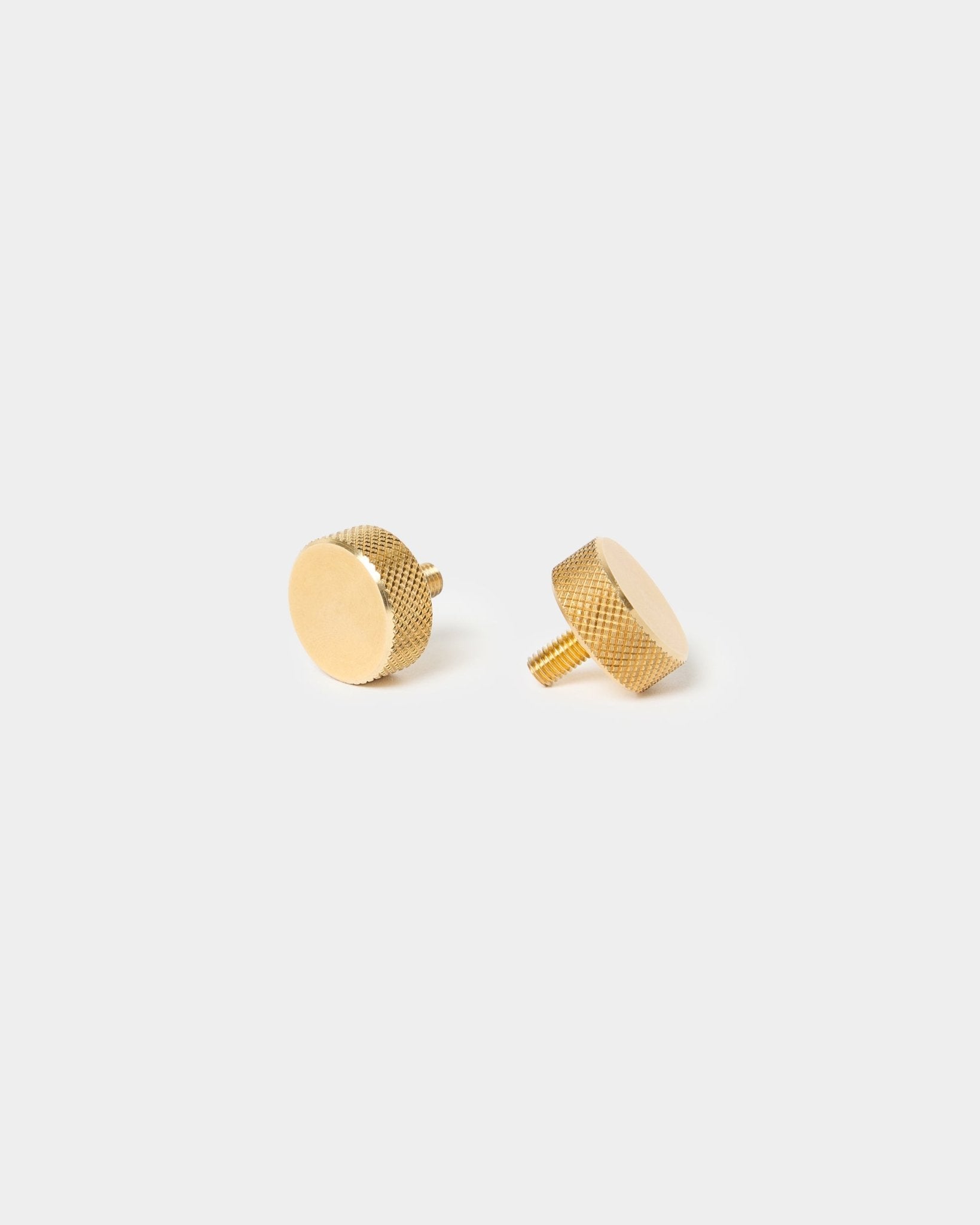 Zwei WoodUpp brass-Rändelschrauben (M5x10 mm, 20x8.8) mit strukturieren Kanten und kurzem Schaft, entwickelt für Akupanel-Accessoires, vor einem schlichten hellen Hintergrund.