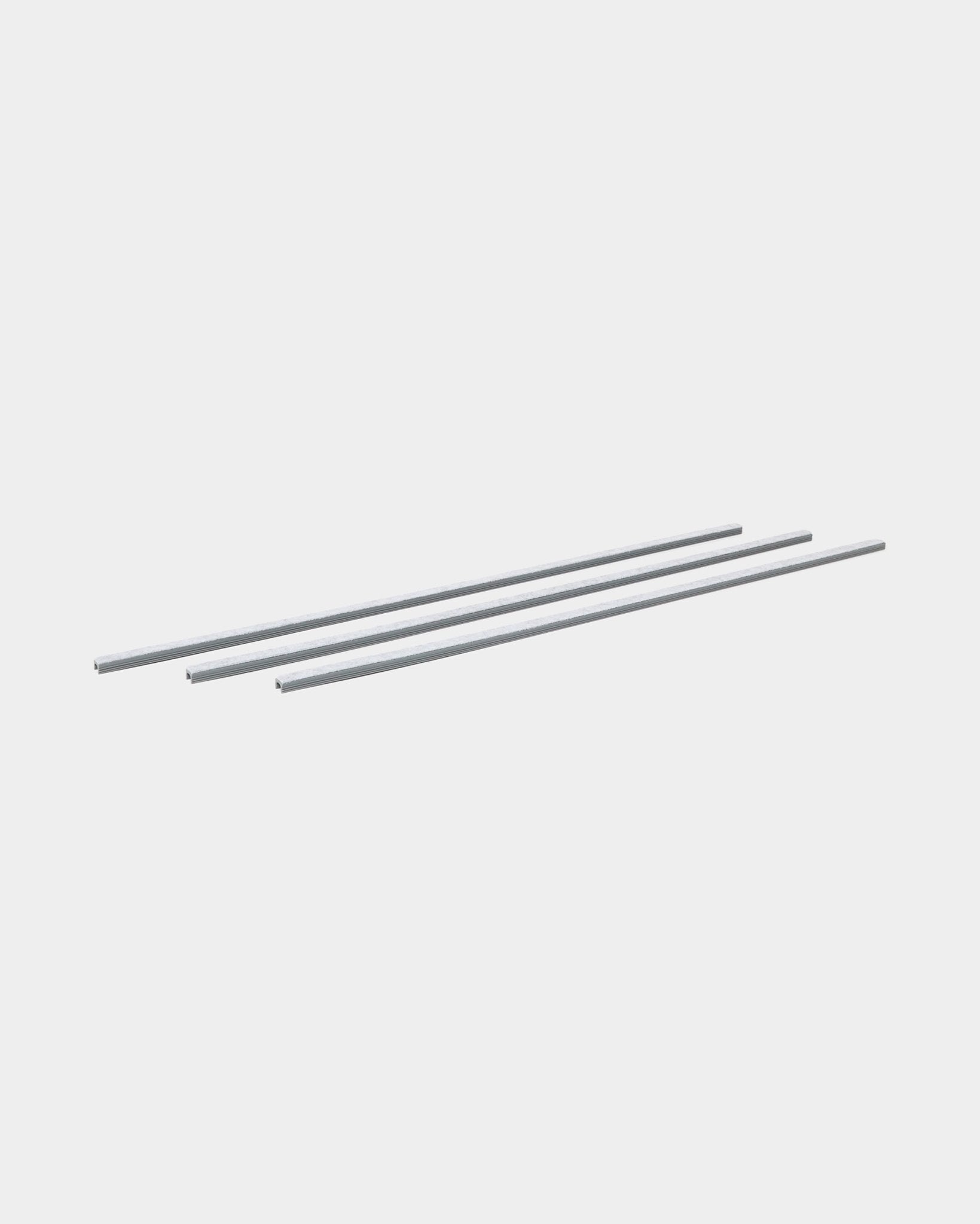 Drei grey Dupps Pop-on-Kabelabdeckungen (3 Stk.) von WoodUpp sind parallel angeordnet und dafür gemacht, Kabel an Akupanel Akustikholzpaneelen zu organisieren.