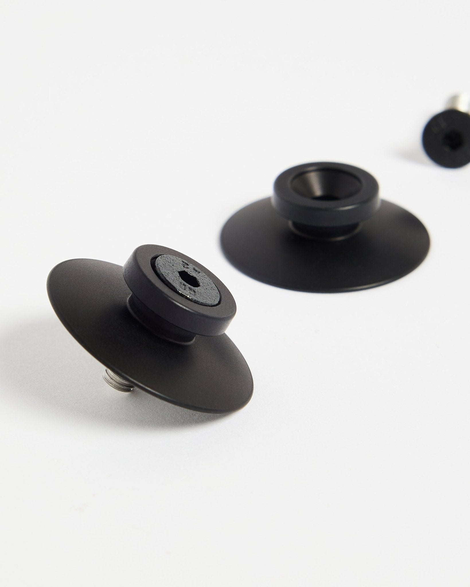 Zwei WoodUpp Dupps Befestigungen aus black Aluminium (2 Stk.) auf einer weißen Fläche, entwickelt für die sichere Montage von Akustikpaneelen oder Raumteilern.