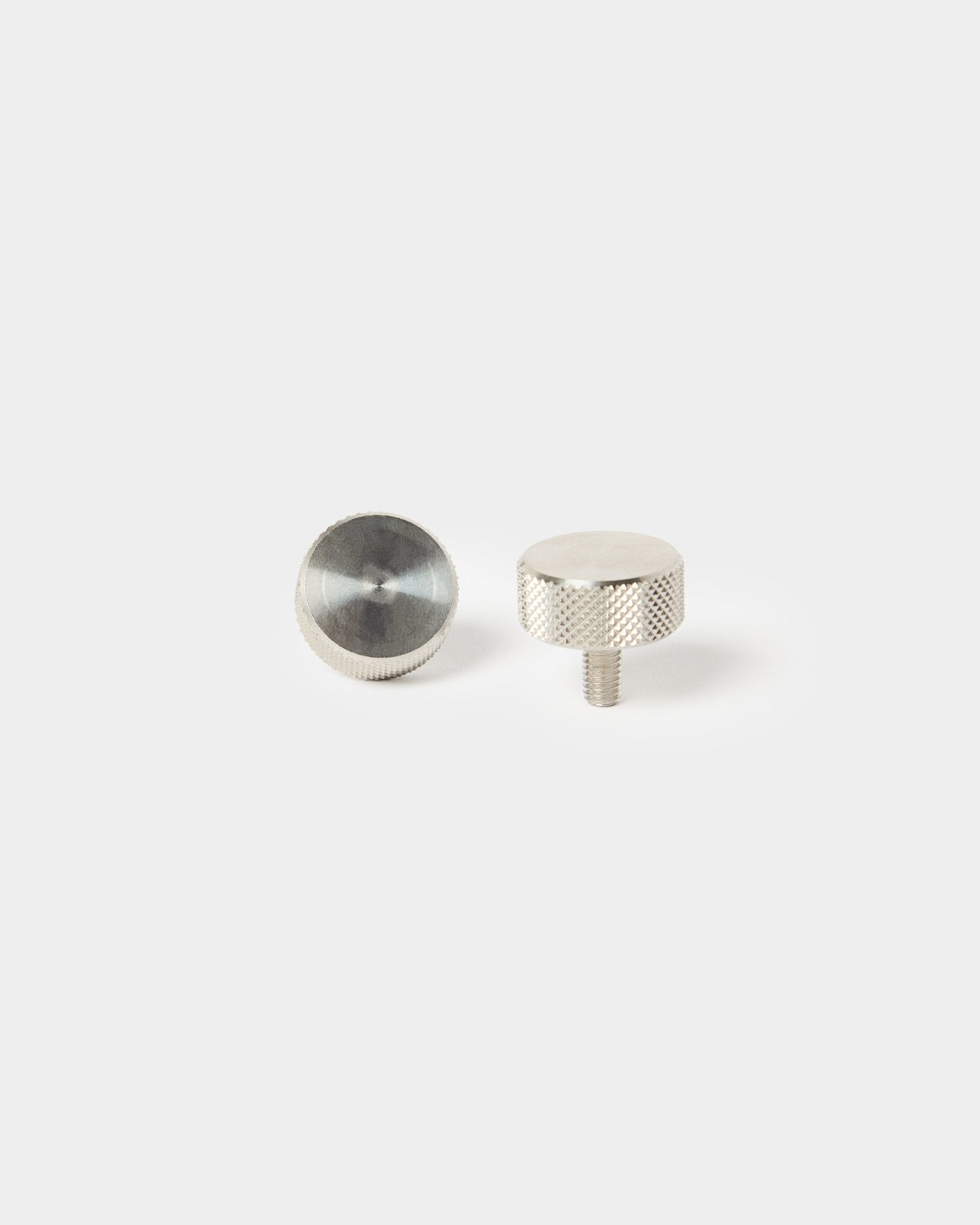 Zwei WoodUpp-Fingerschrauben aus rostfreiem steel (M5x10 mm, 20x8.8) für die Montage von Akustikpaneelen – ein Ende mit Gewinde, eins mit glattem Kopf.