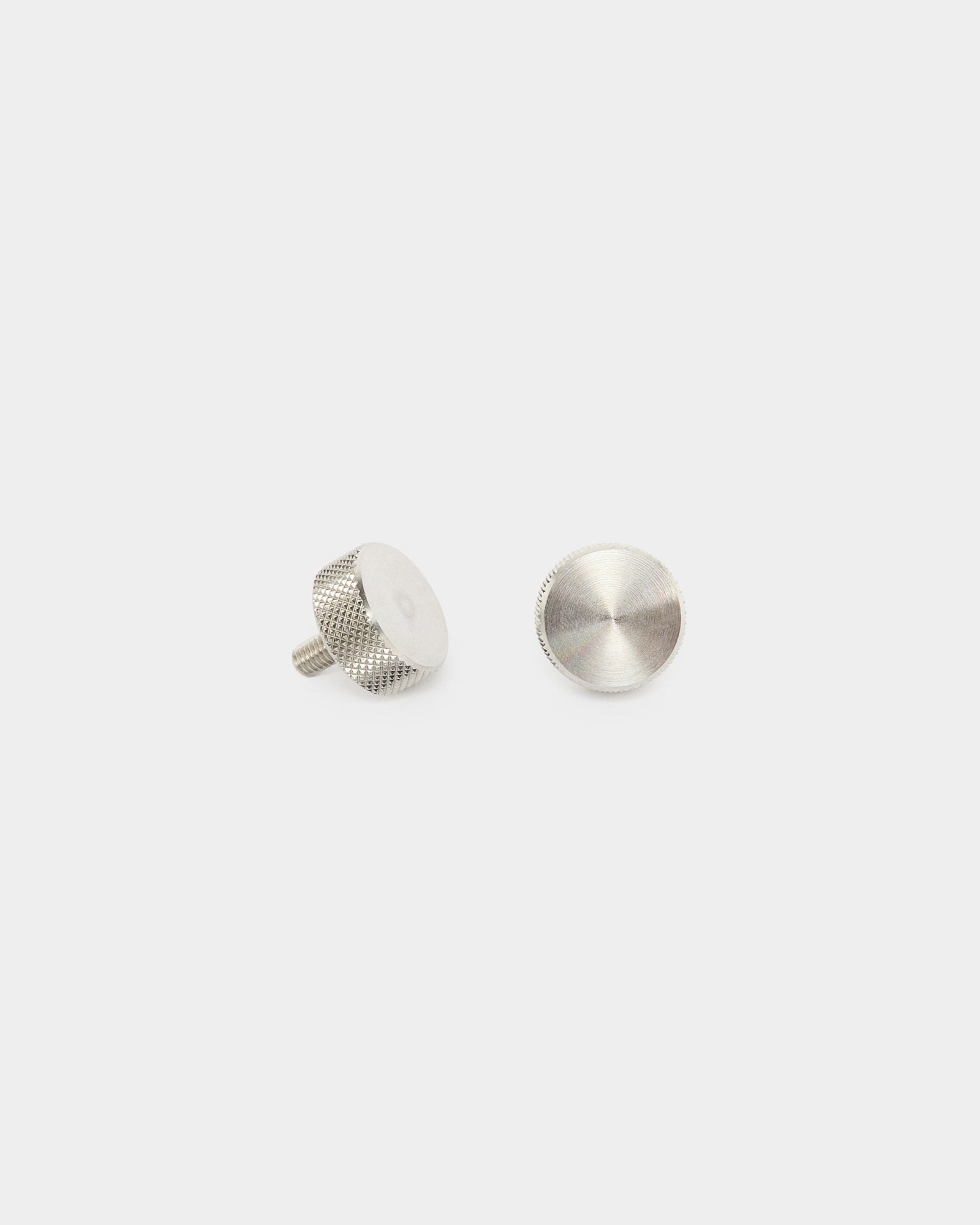 Zwei WoodUpp-Fingerschrauben aus rostfreiem steel (M5x10 mm, 20x8.8), Zubehör für Akupanel Akustikpaneele, auf schlicht weißem Hintergrund stehend und flach dargestellt.