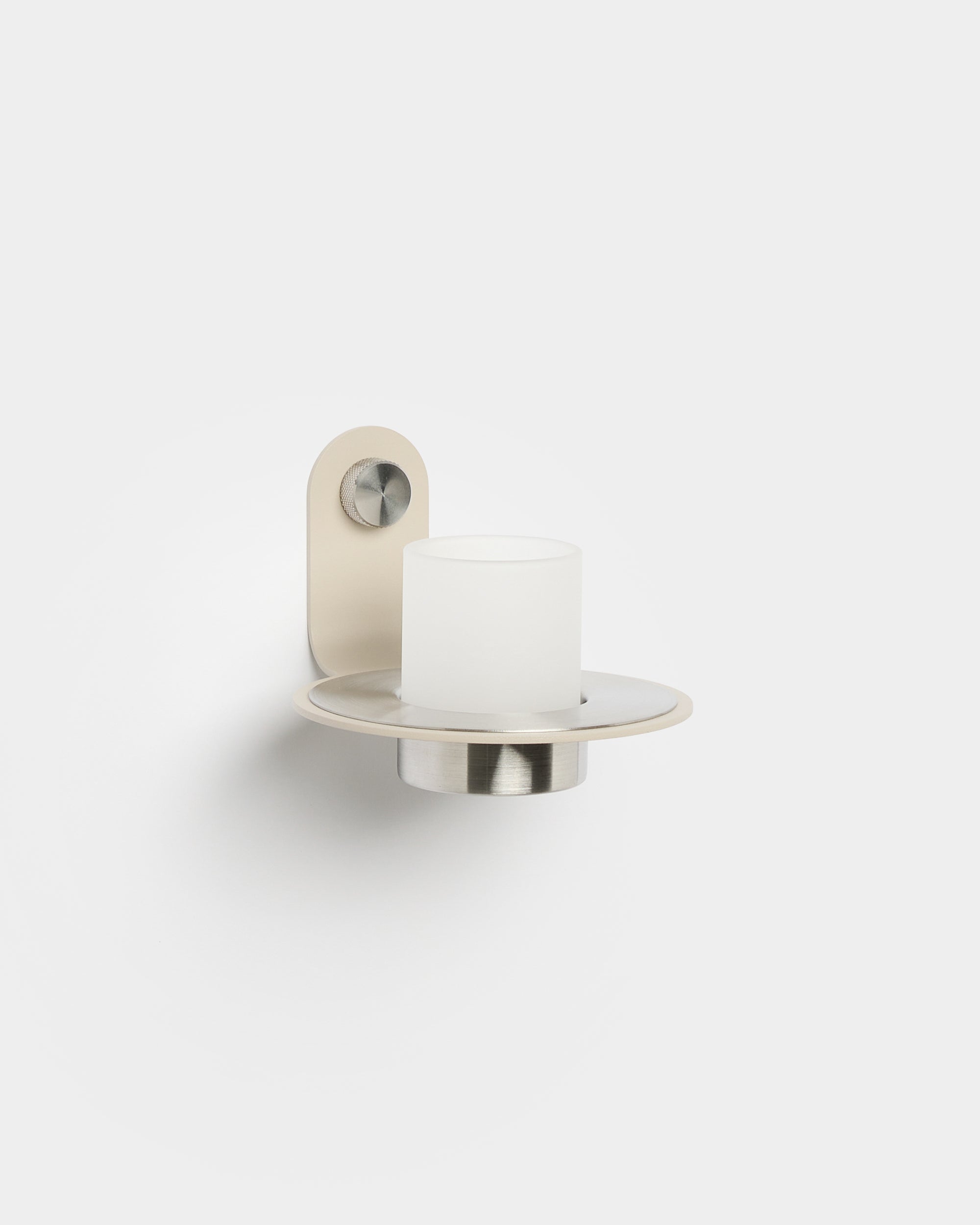 Le bougeoir Norr de WoodUpp, avec une base en steel inoxydable beige, posé sur un panneau acoustique Akupanel Panneau acoustique pour une touche nordique moderne.