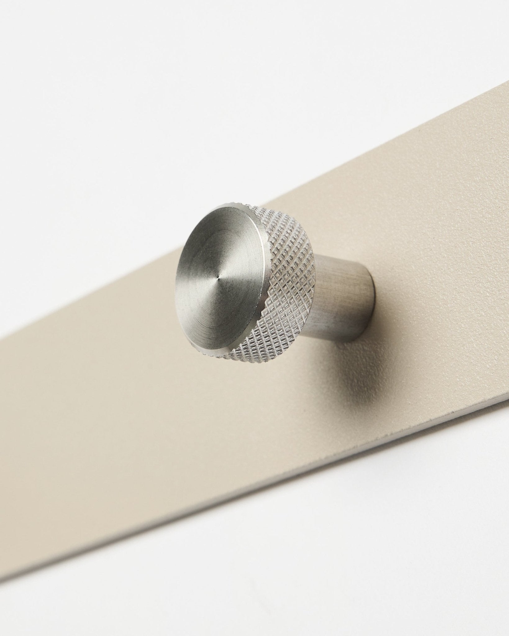 Gros plan sur la patère WoodUpp Norr en beige et steel inoxydable, X7, conçue comme accessoire pour les panneaux acoustiques en bois Akupanel ou pour organiser l’entrée.