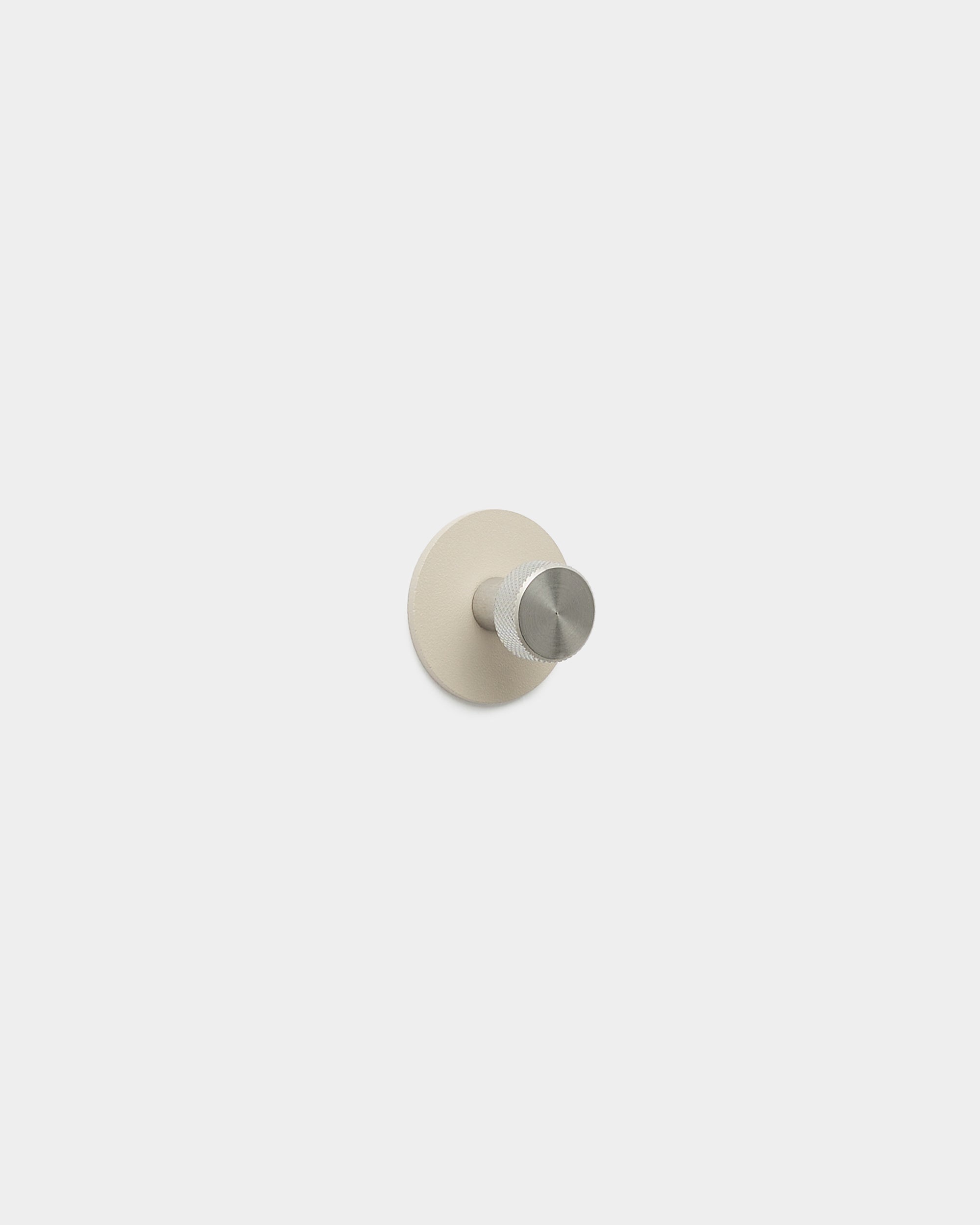 WoodUpp Norr Kleiderhaken in beige und rostfreiem steel mit minimalistischem Haken und runder Basis, gefertigt aus pulverbeschichtetem steel, Teil des WoodUpp Zubehörs.