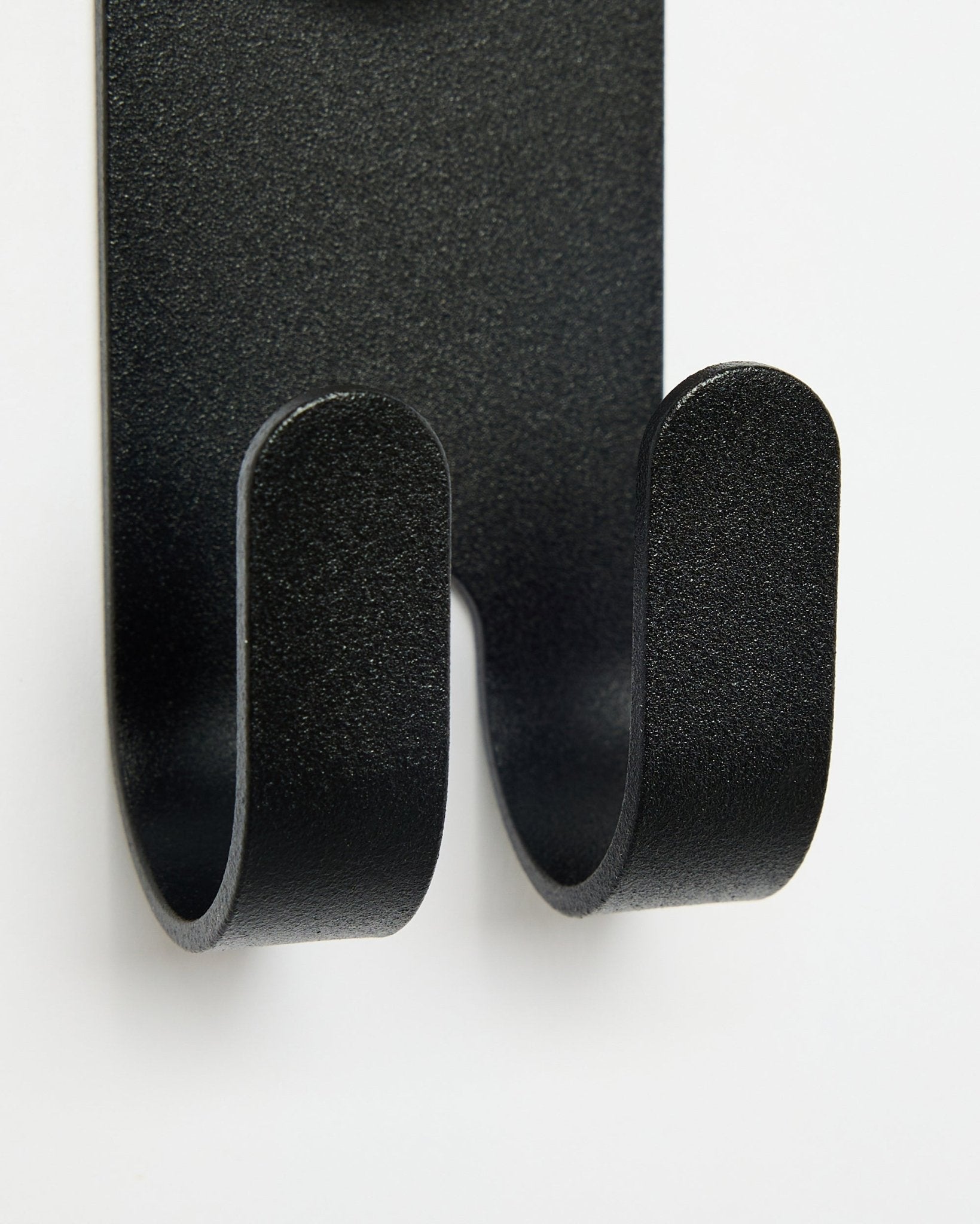 Gros plan sur le Norr Double Hanger en black de WoodUpp, montrant des crochets doubles conçus pour les accessoires Akupanel sur fond blanc.