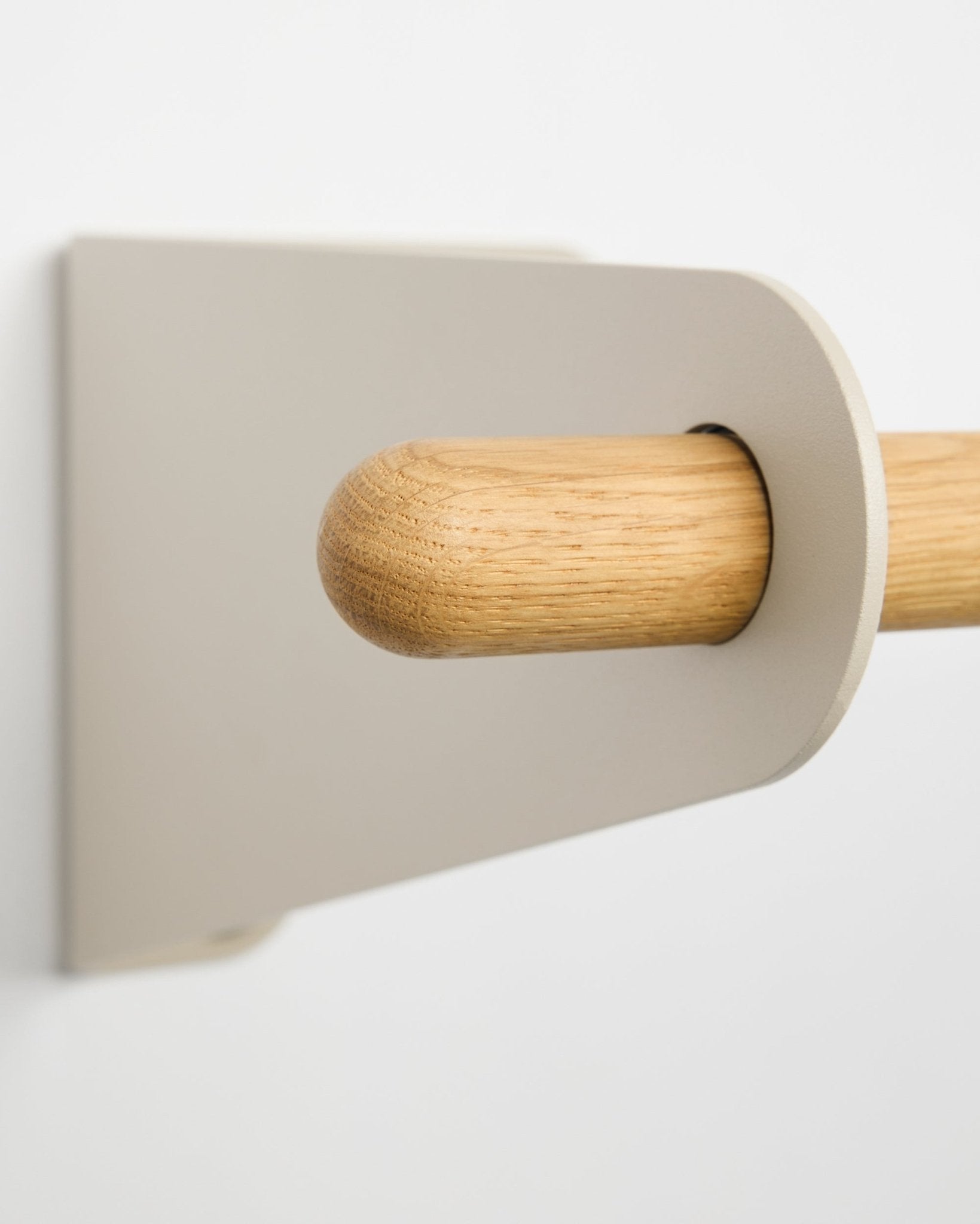 Nahaufnahme der WoodUpp Linn Garderobenstange in beige, 115,9 cm, mit einer hellen beigefarbenen Metallhalterung, montiert an einer weißen Wand. Nordisches minimalistisches Design-Accessoire.