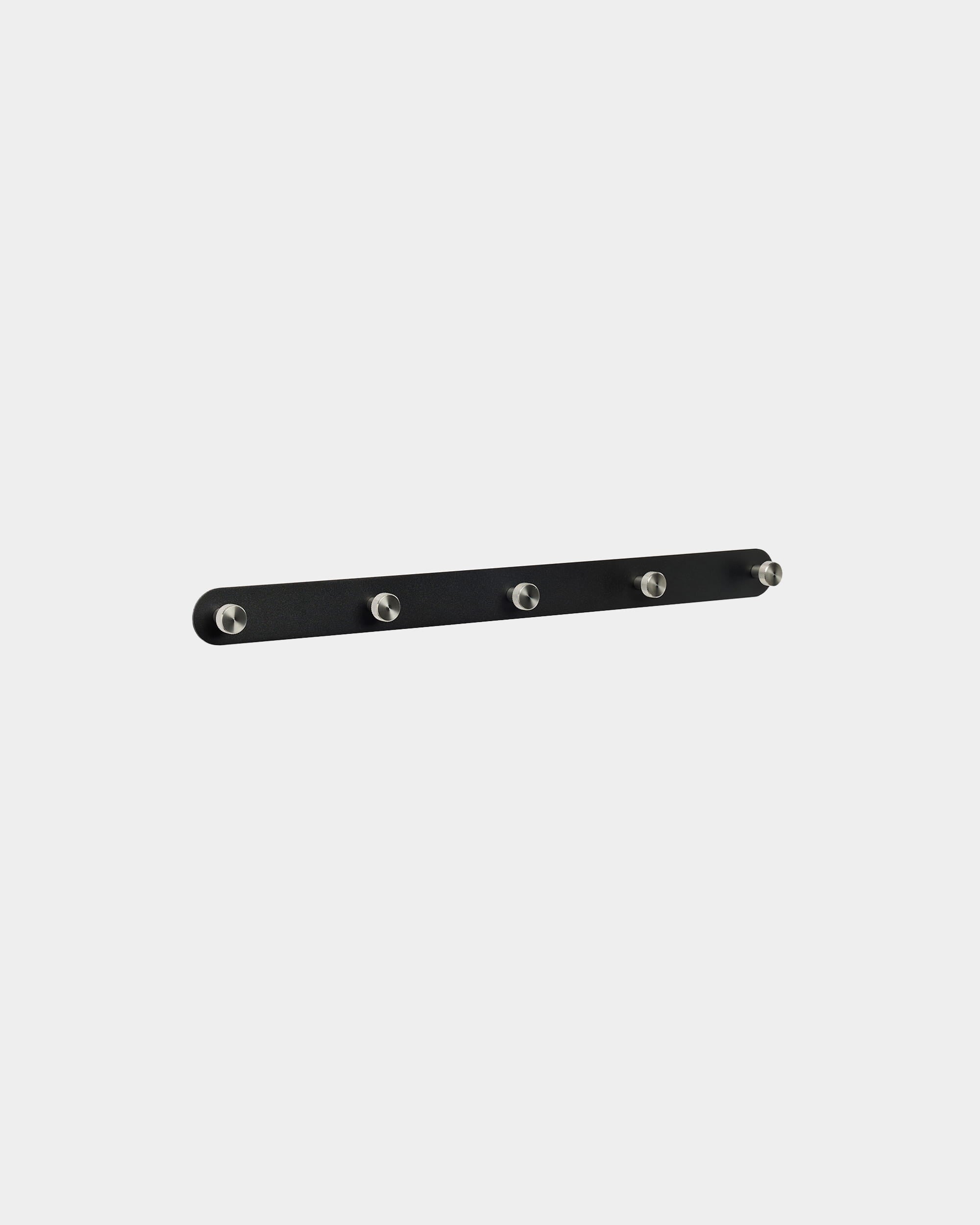 Patère WoodUpp Norr X5 en black et steel inoxydable, avec cinq crochets régulièrement espacés, montée sur un fond blanc uni. Design minimaliste nordique.