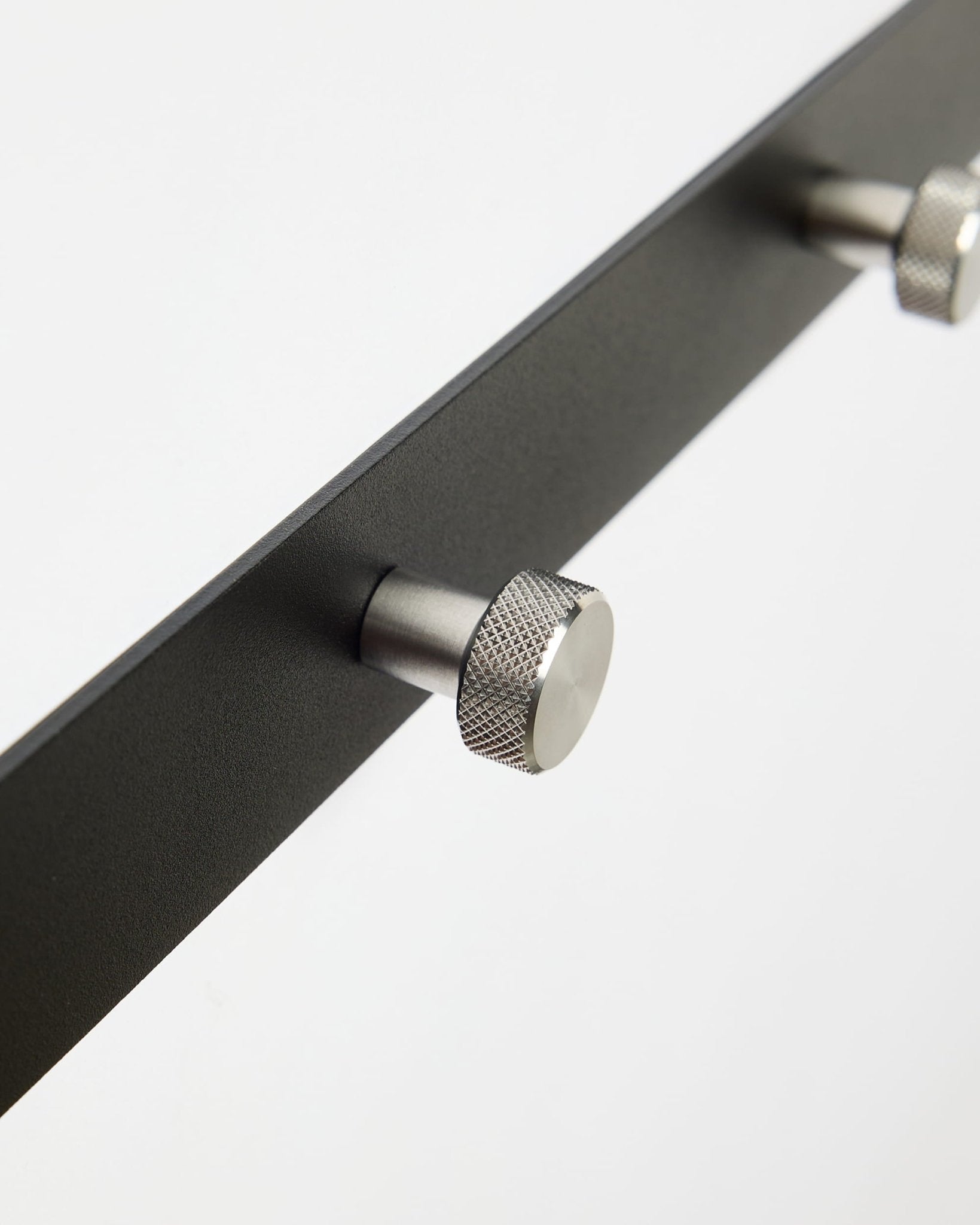 Gros plan sur Norr | Coat Hook Rack / X5 de WoodUpp en black et steel inoxydable, conçu comme accessoire pour les panneaux acoustiques Akupanel ou pour une utilisation dans l’entrée.