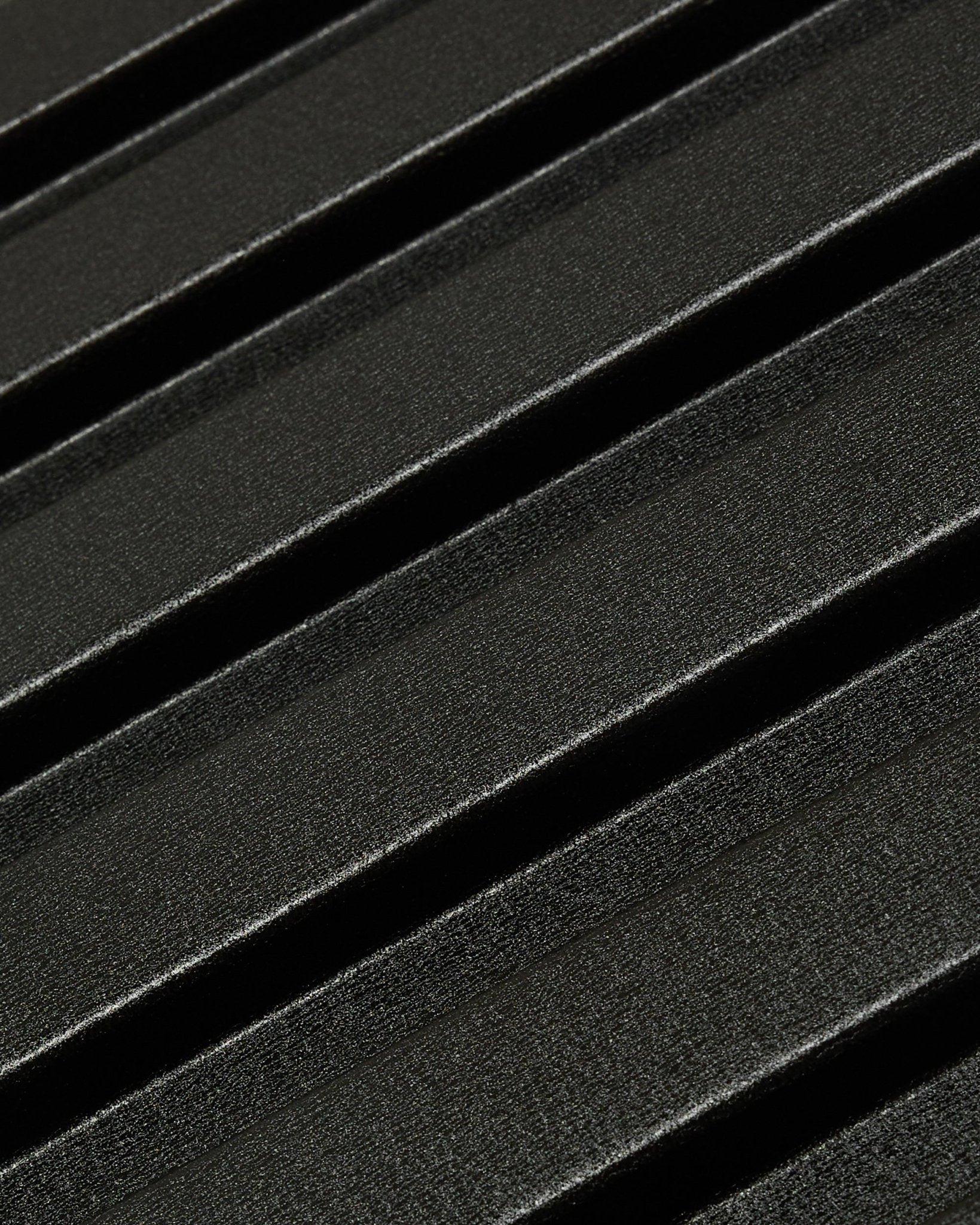 Gros plan sur le panneau de façade extérieur Aluwood de WoodUpp : surface sombre et texturée en aluminium recyclé, avec des reliefs diagonaux, dimensions 240 x 45,1 cm.