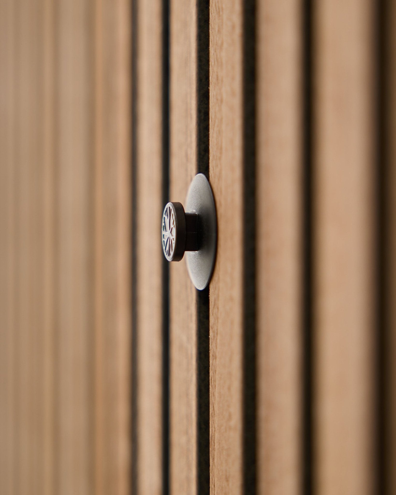 Gros plan sur un lot de boutons Dupps | Light (3 boutons + outil) de WoodUpp installé sur un panneau mural acoustique à lattes, avec des lattes en bois délicatement floutées à l’arrière-plan.