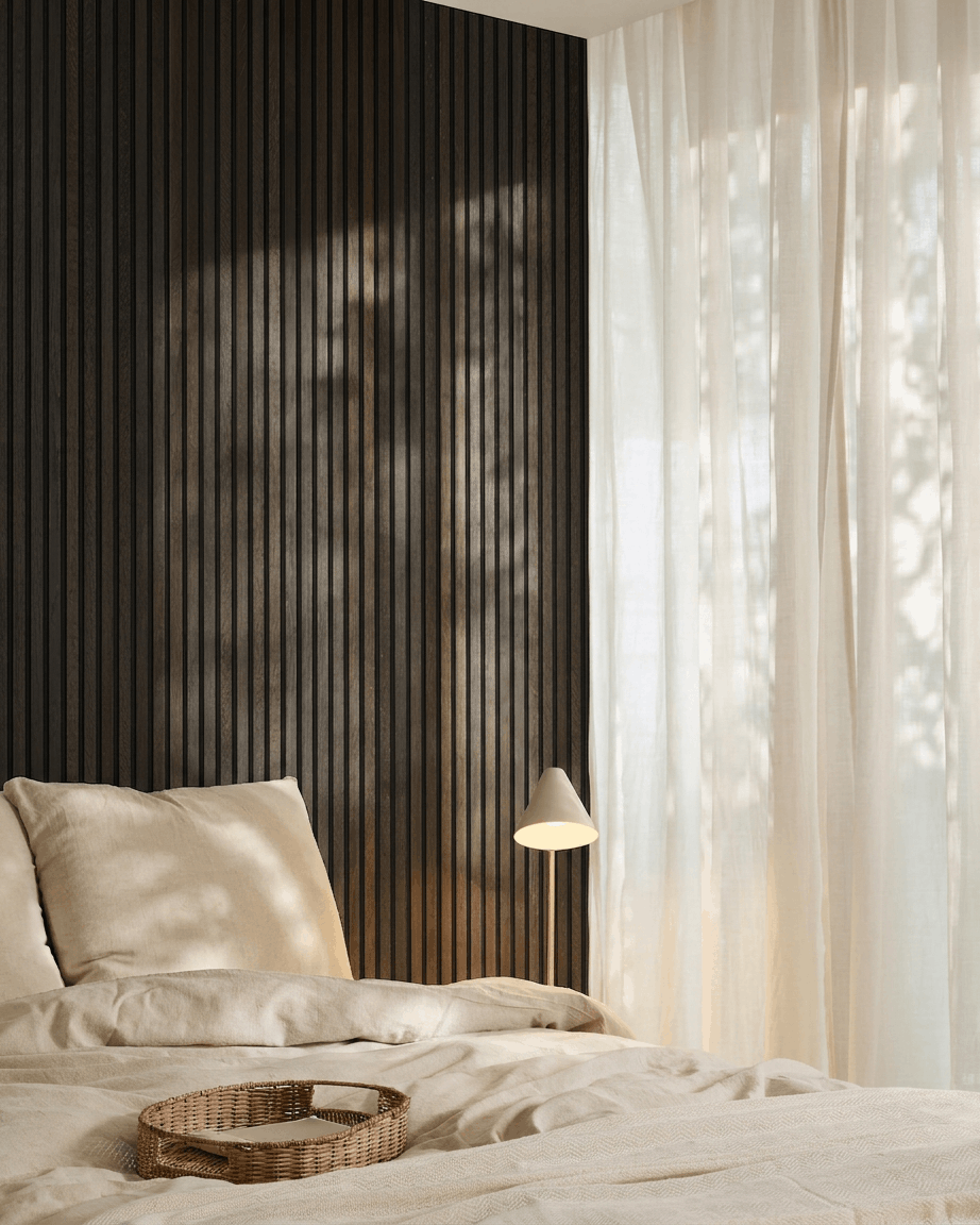 Chambre minimaliste avec un lit beige, un plateau en osier, des touches scandinaves et le panneau acoustique en bois Akupanel de WoodUpp en Rustic Smoked Oak, monté sur un mur sombre.