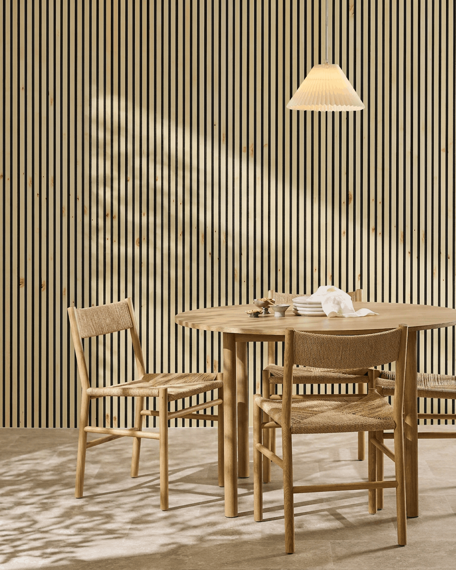 Le panneau acoustique WoodUpp Akupanel, disponible en bois naturel, en « alp » et en feutre noir, apporte une touche nordique chaleureuse et minimaliste à un coin repas de style scandinave composé dune table et de chaises.