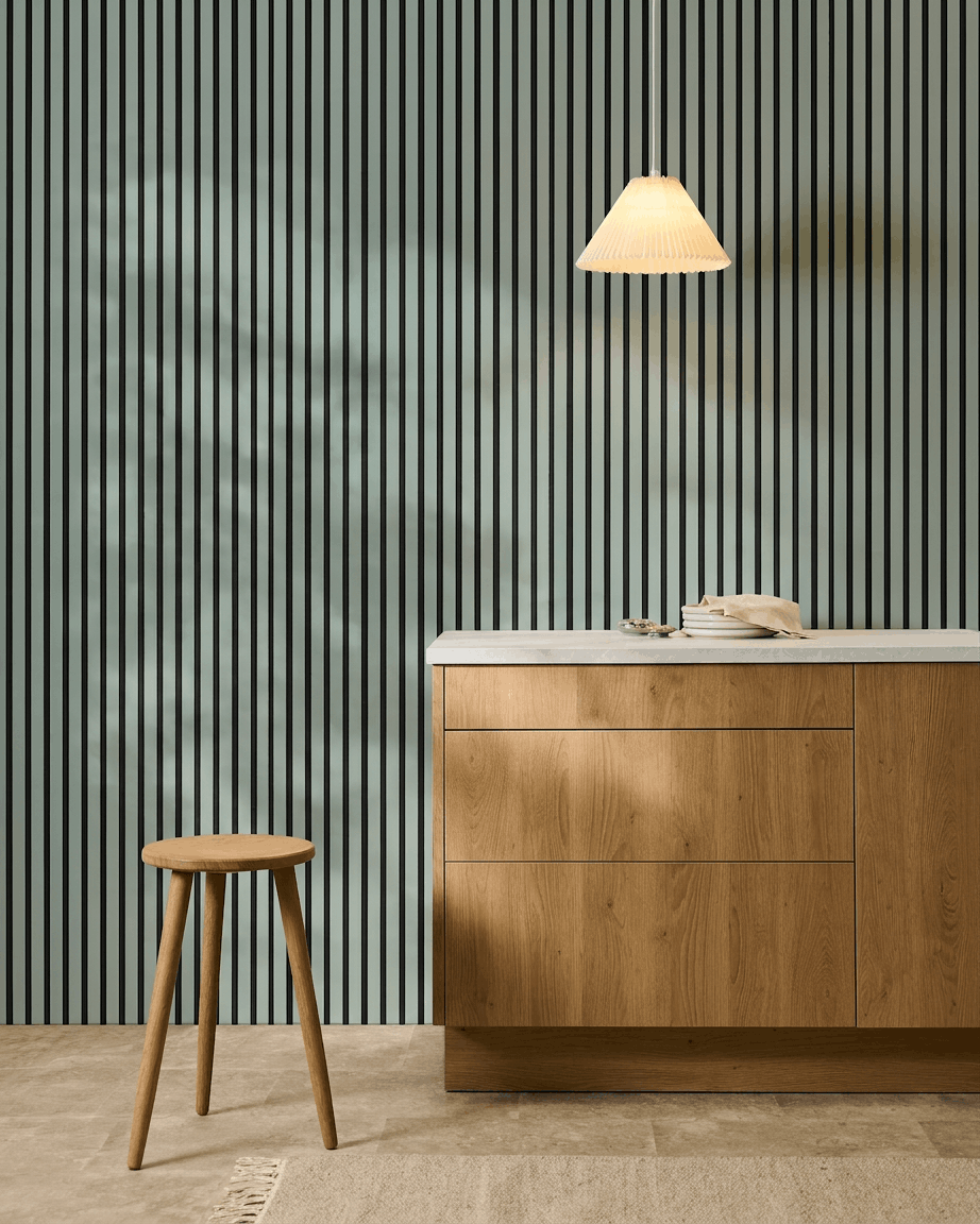 Cuisine nordique minimaliste avec un tabouret en bois, un meuble de rangement et un panneau acoustique WoodUpp Akupanel Panneau acoustique en coloris Cloud avec feutre black (240x60cm), pour un meilleur confort acoustique.