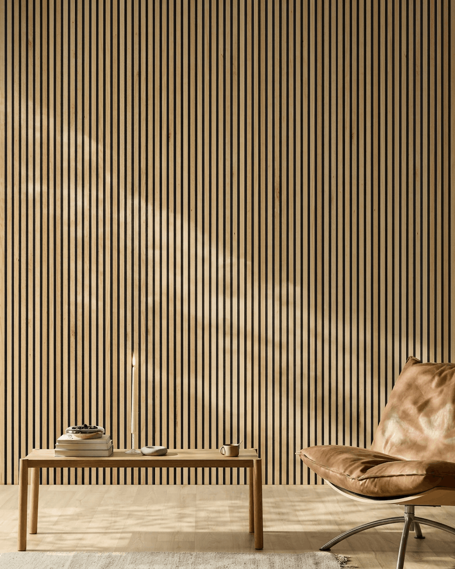 La lumière du soleil illumine une pièce moderne dont les murs sont ornés dun panneau acoustique WoodUpp Akupanel en chêne naturel rustique, à côté dun fauteuil en cuir beige et dun banc minimaliste.
